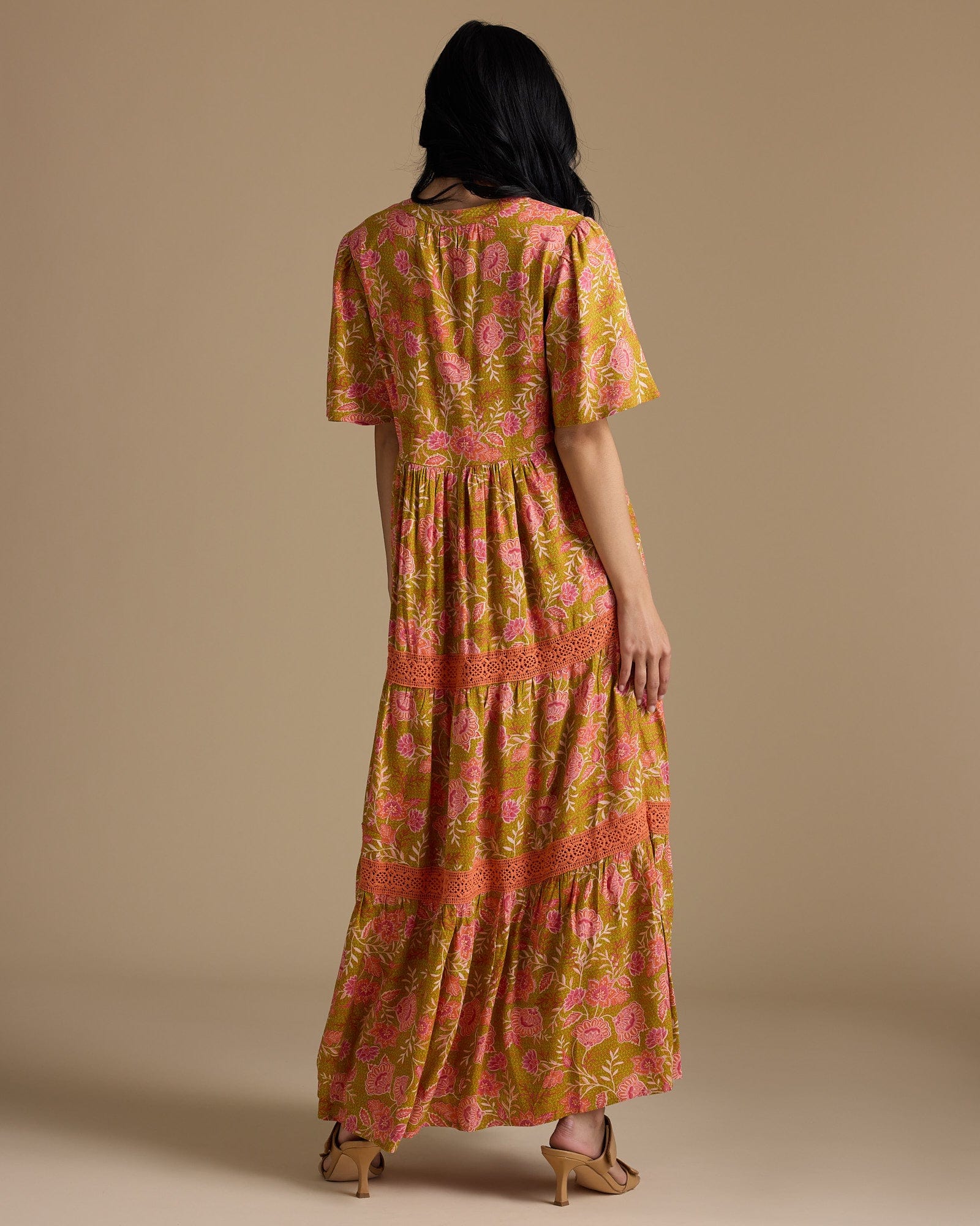 Woman in a half sleeve, maxi-length, orange and gold dress