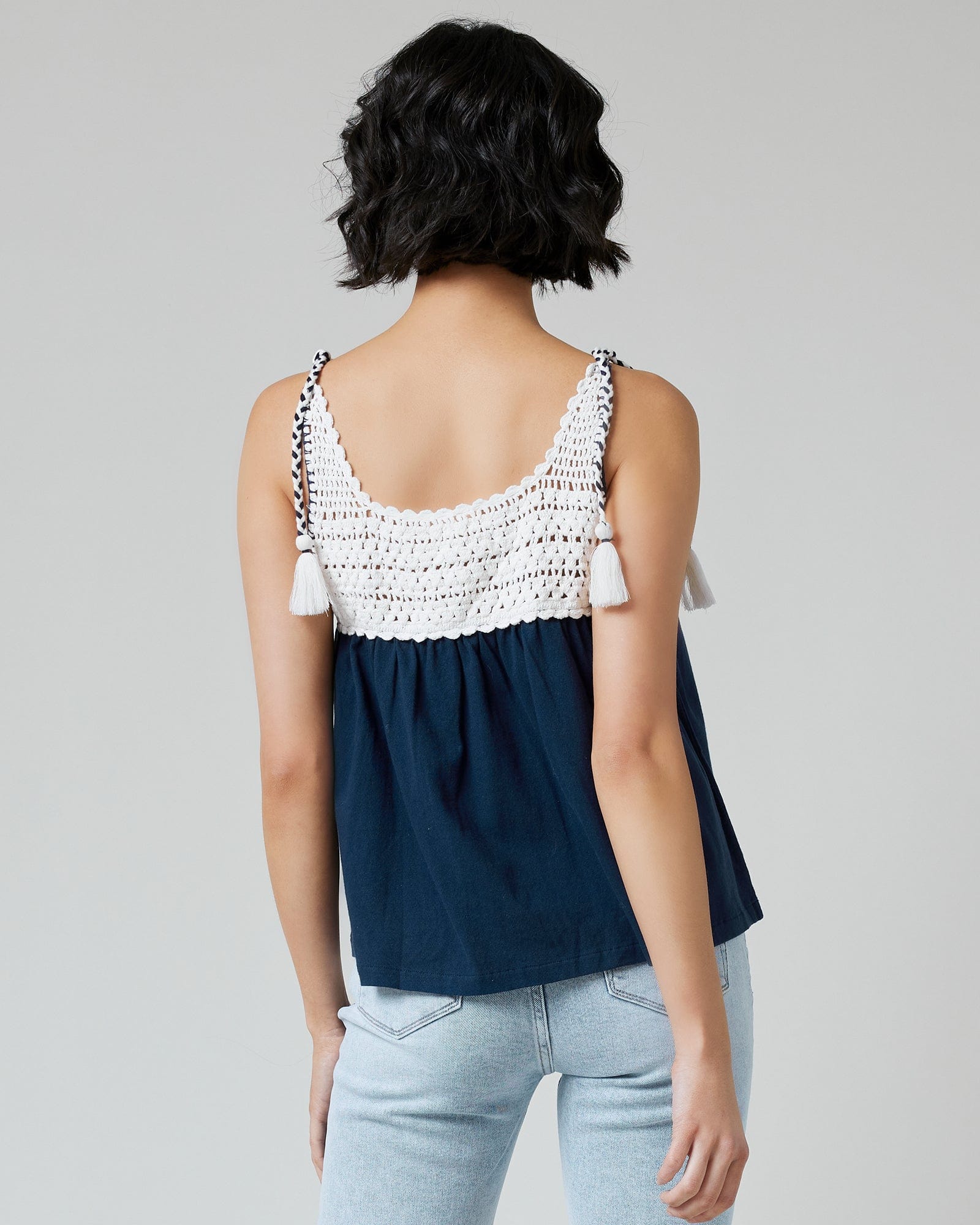 Woman in a navy tank top with crocheted fabric at top