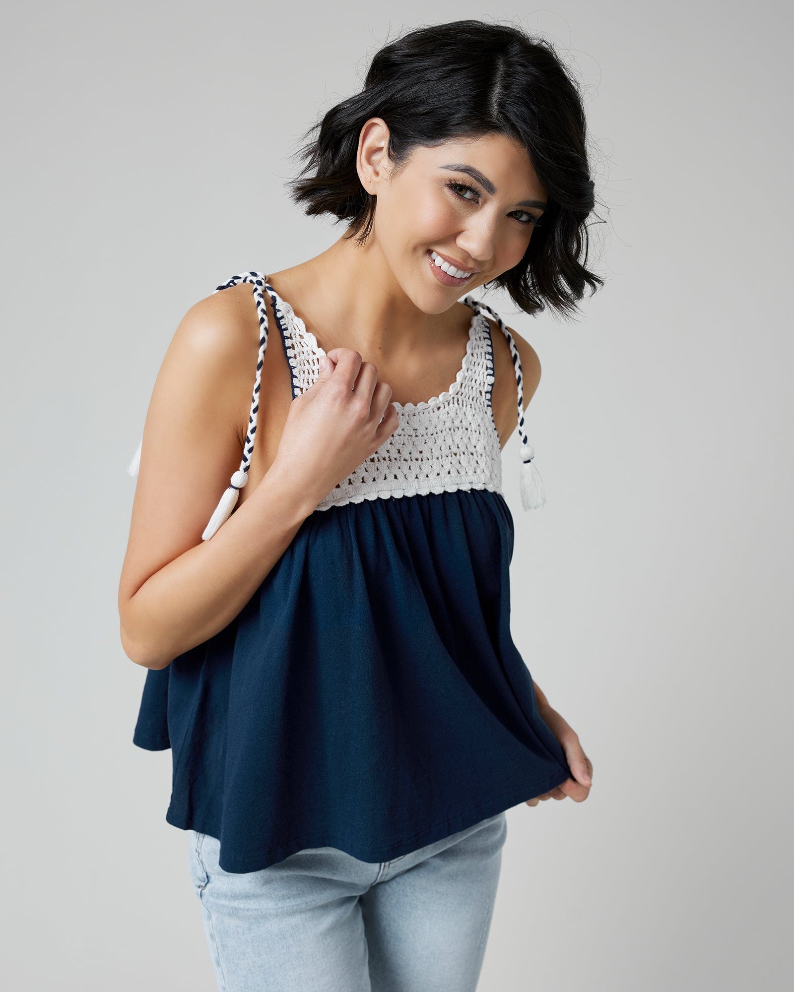 Woman in a navy tank top with crocheted fabric at top