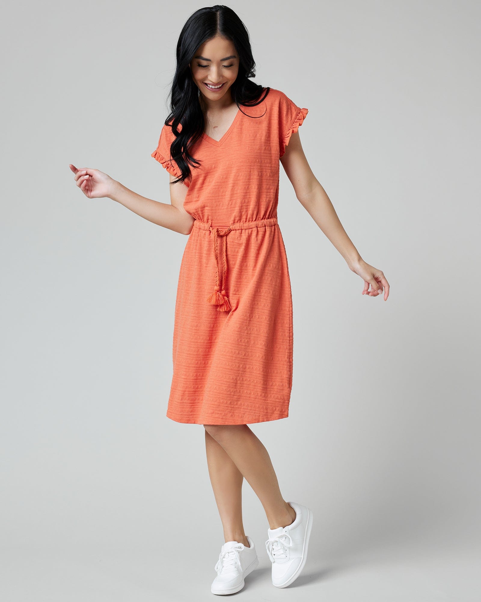 Woman in a short sleeve, v-neck, textured, orange dress