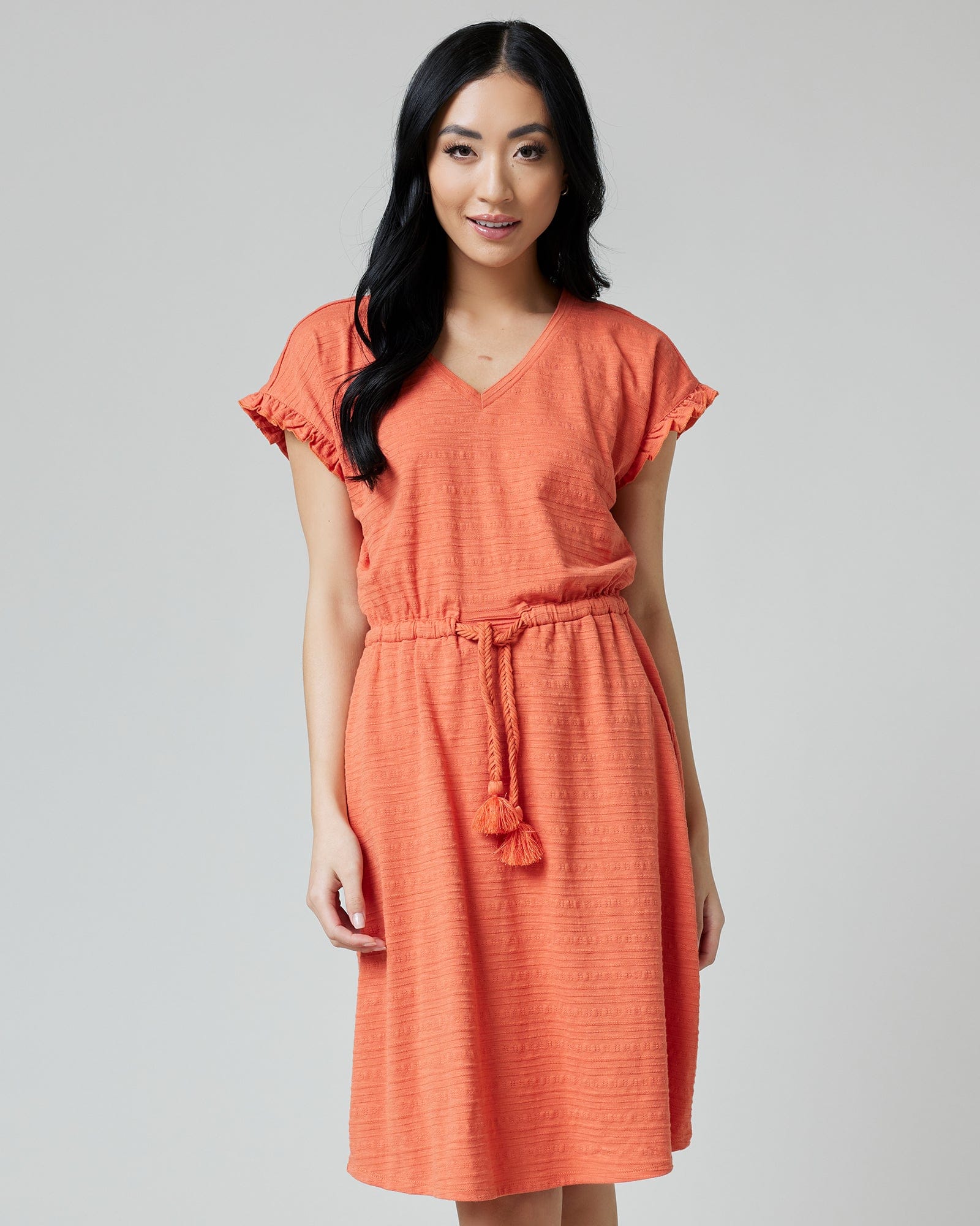 Woman in a short sleeve, v-neck, textured, orange dress