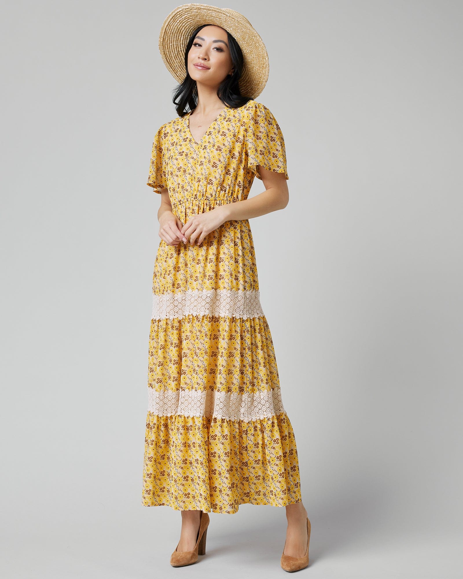 Woman in a short sleeve, maxi-length, yellow with floral print dress