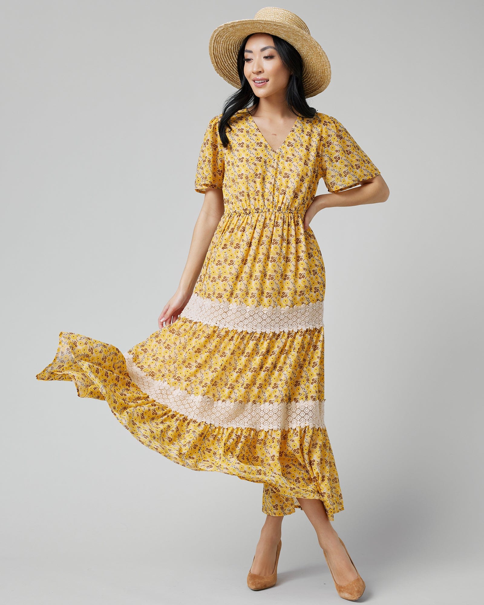 Woman in a short sleeve, maxi-length, yellow with floral print dress