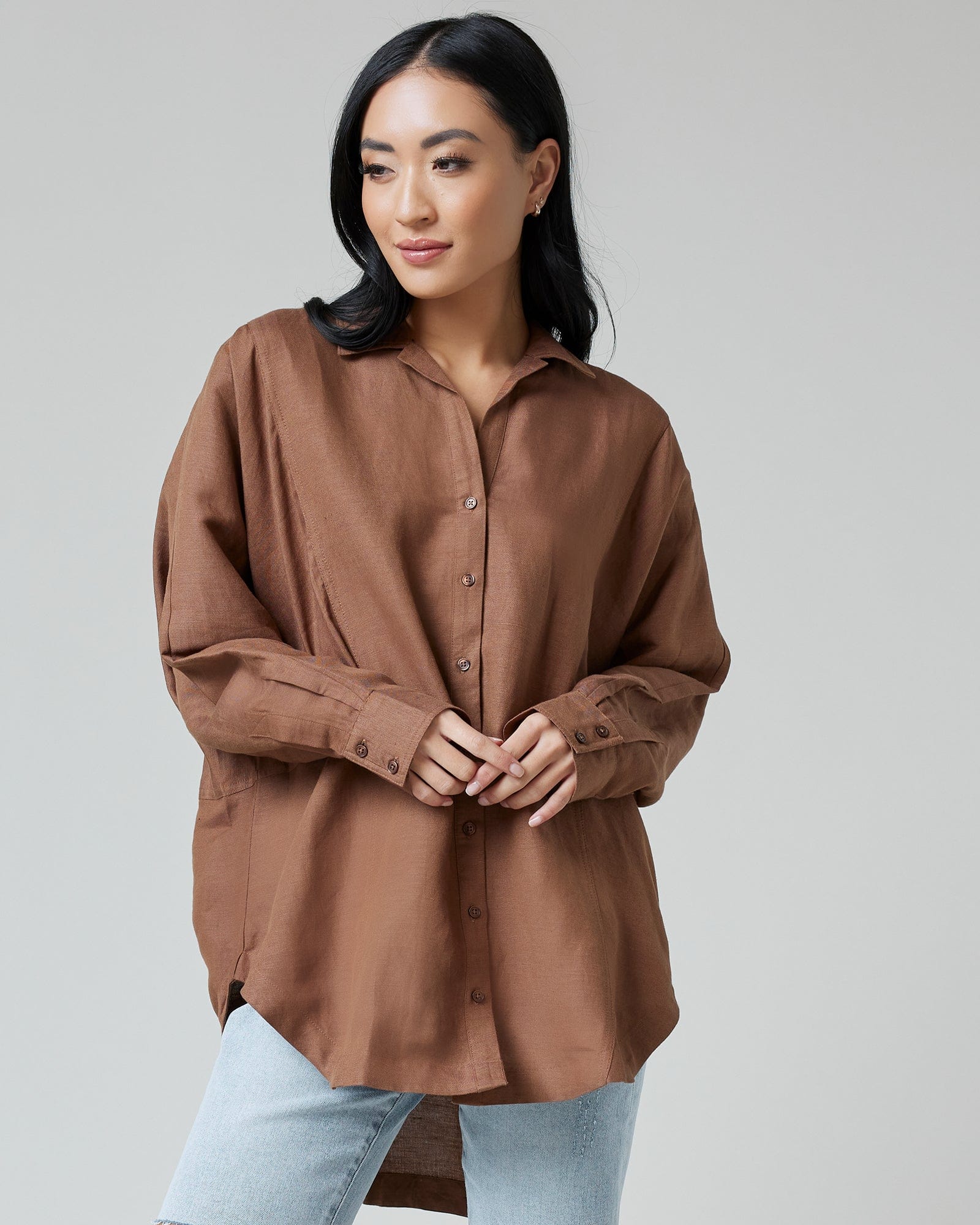 Woman in a brown oversized long sleeve button-down