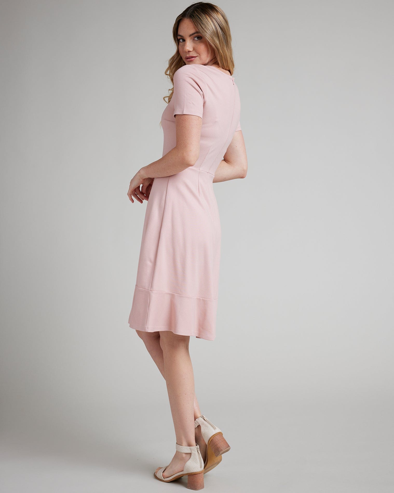 Woman in a short sleeve, knee-length simple pink dress