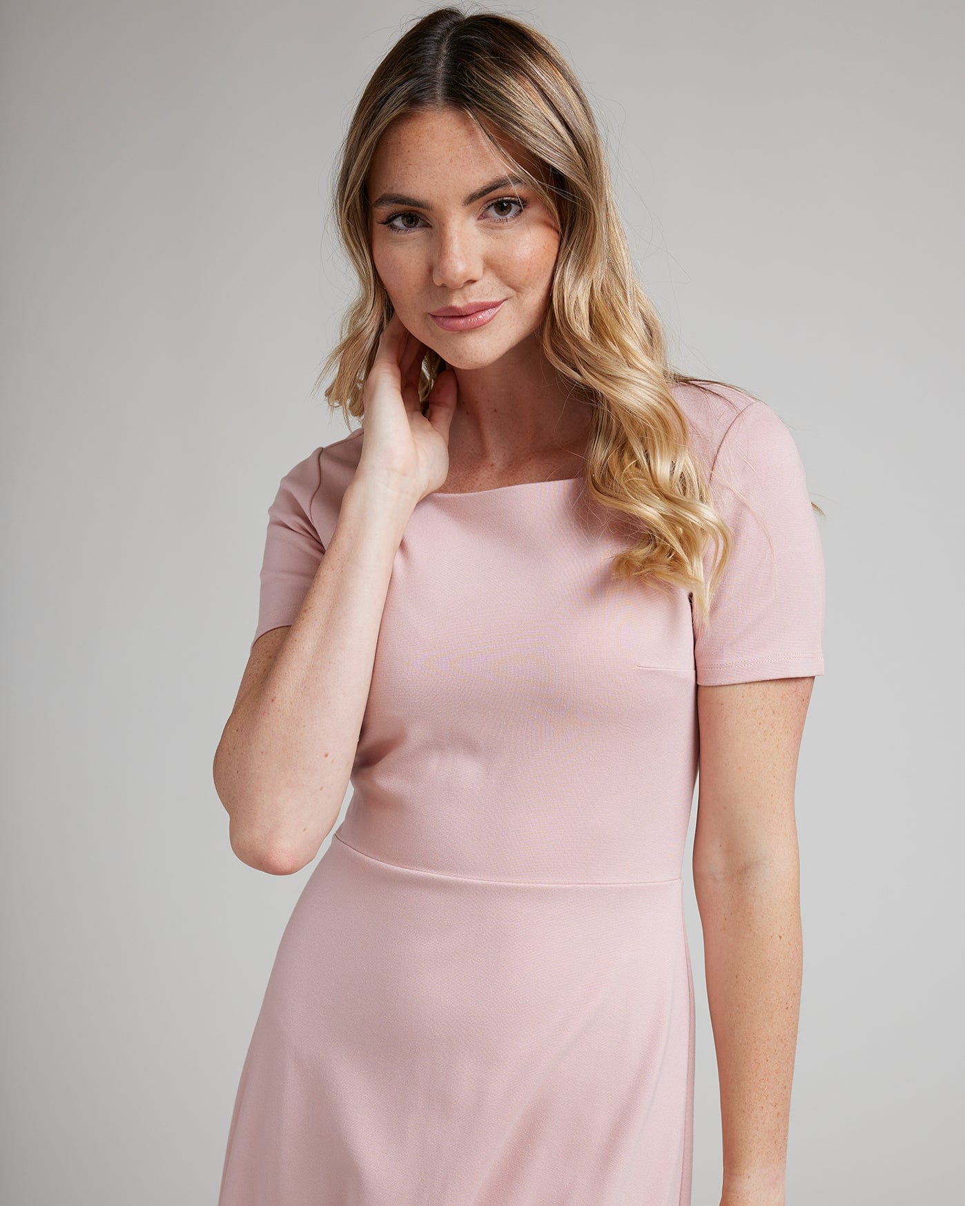 Woman in a short sleeve, knee-length simple pink dress