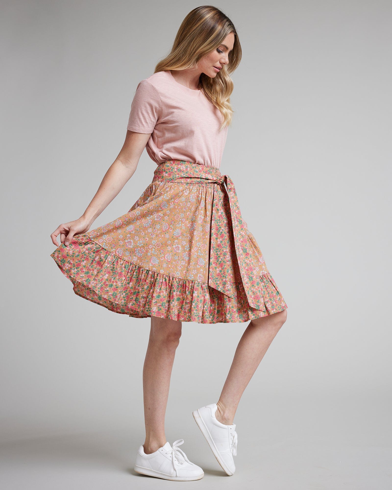 Woman in pink floral knee-length skirt