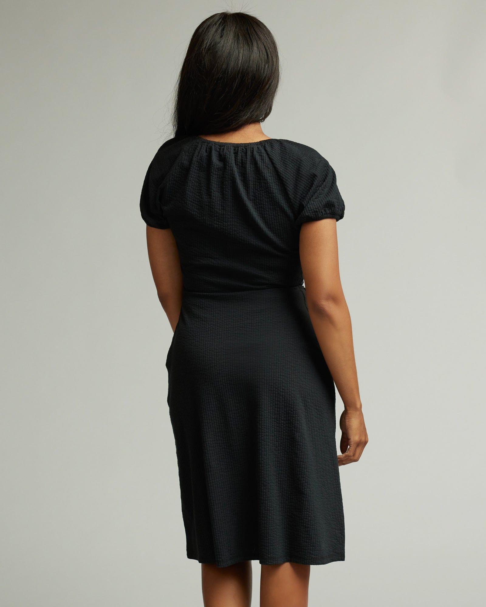 Woman in a short sleeve, knee-length, black dress