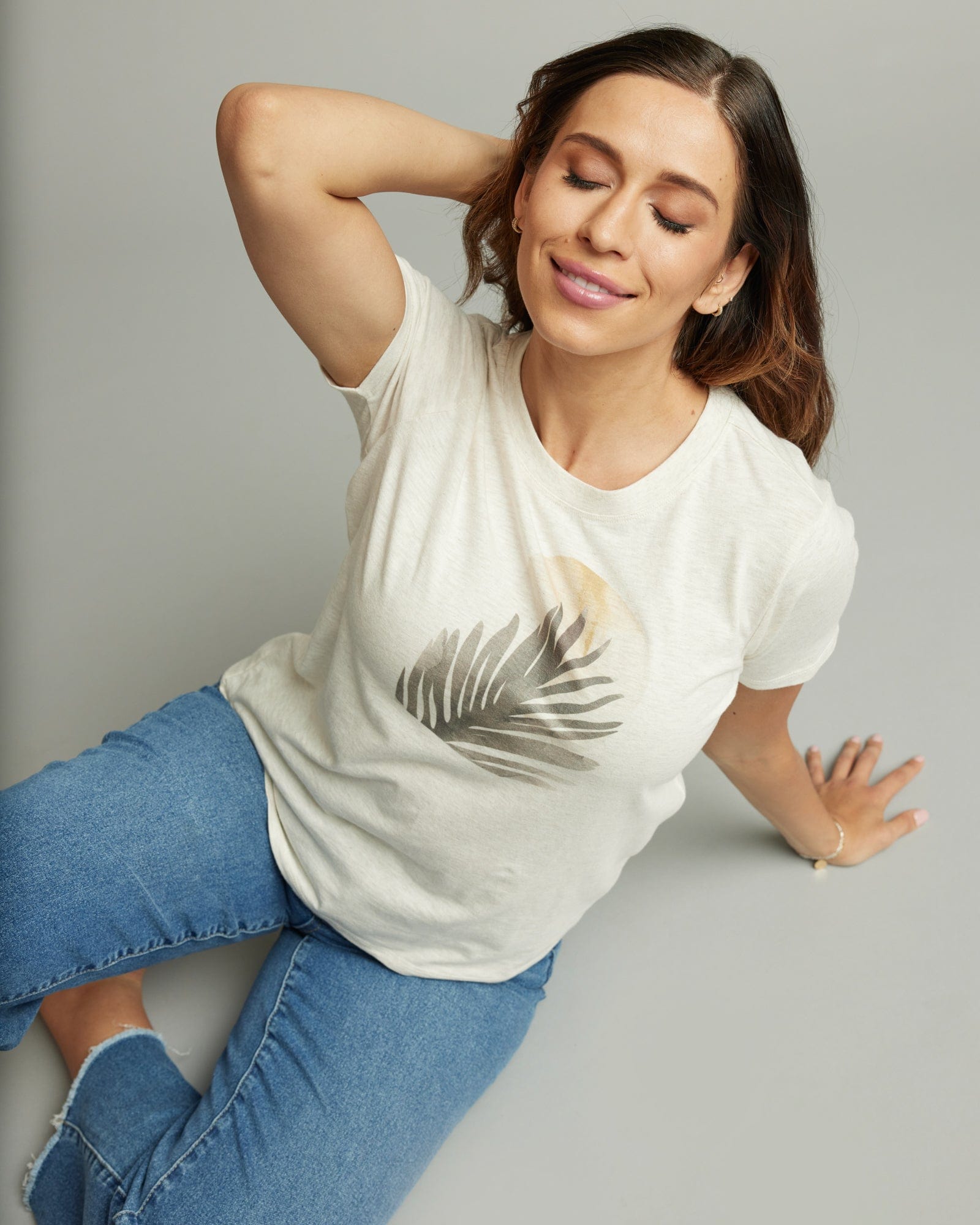 Woman in a short sleeve white graphic tee with a moon and plant design on front