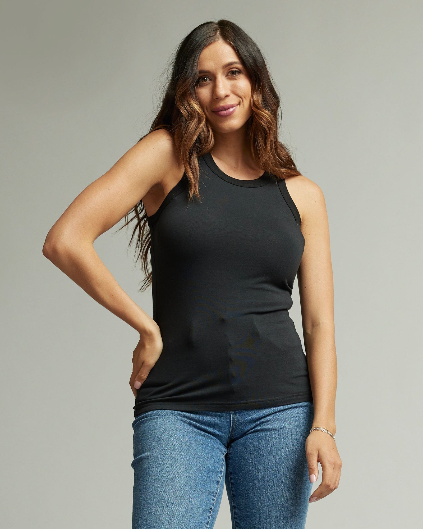 Woman in sleeveless, fitted, high neck, basic tank top