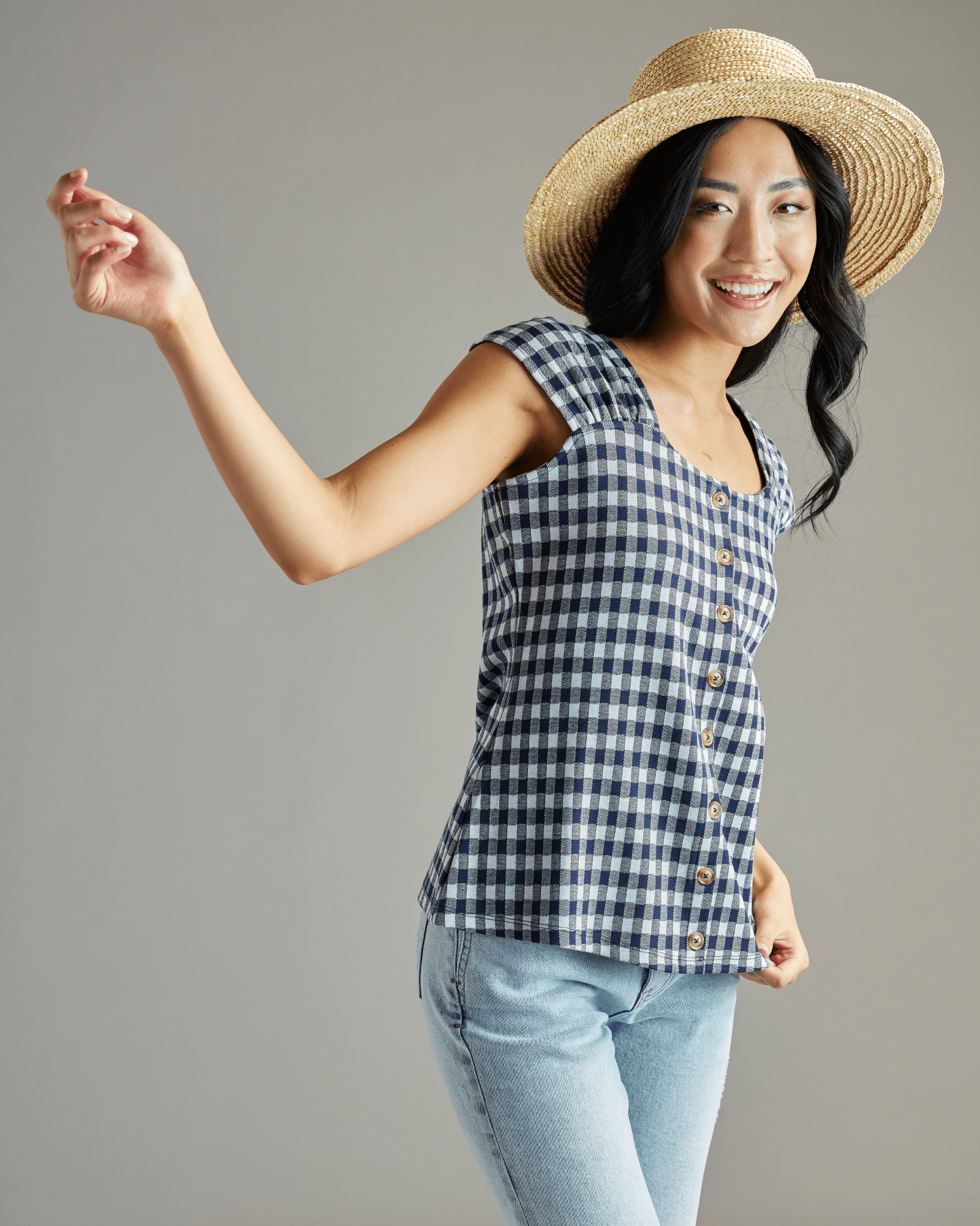 Woman in a navy and white gingham blouse with short sleeves and buttons down the front