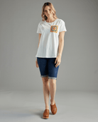 Woman in a white t-shirt with short sleeves and a crochet patch on chest