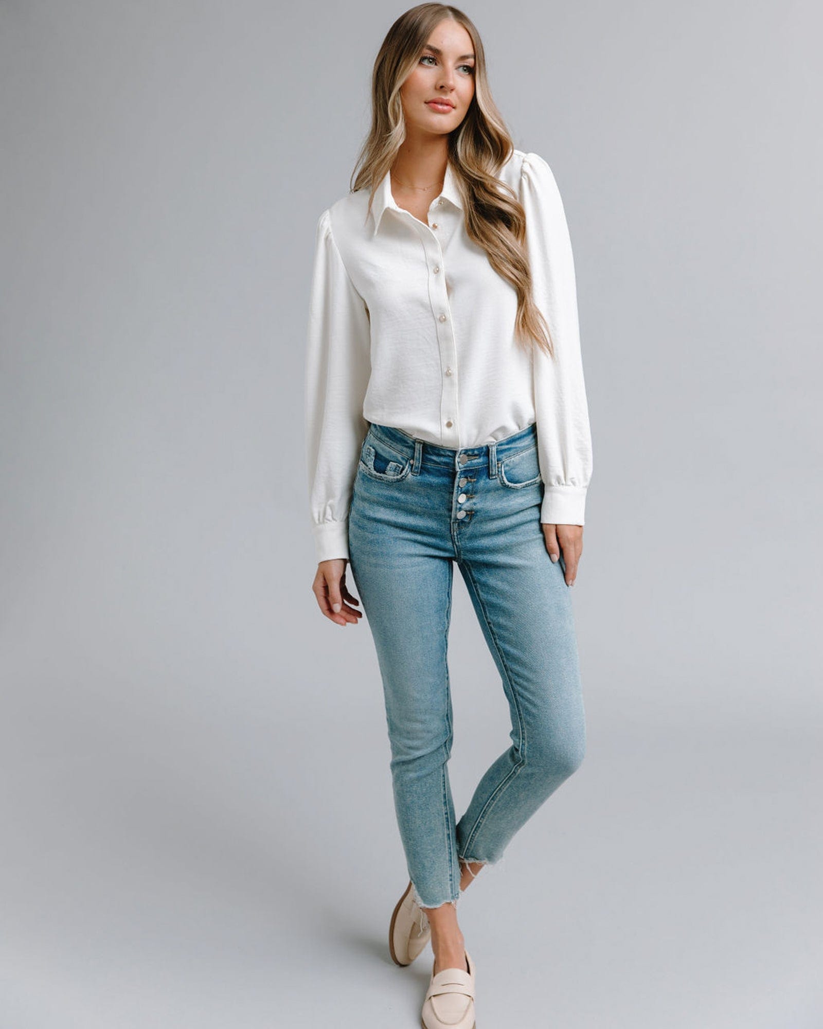 Woman in a long sleeve, collared, white button-down blouse