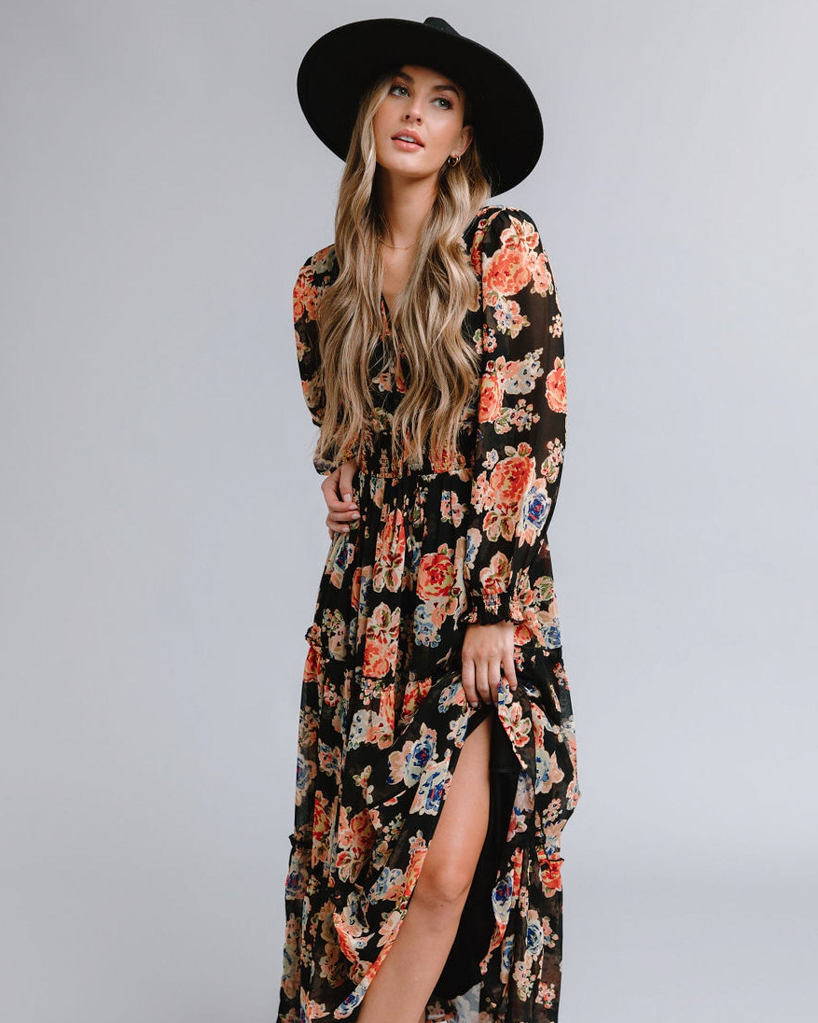 Woman in a long sleeve, maxi length, black with multi-color floral accents