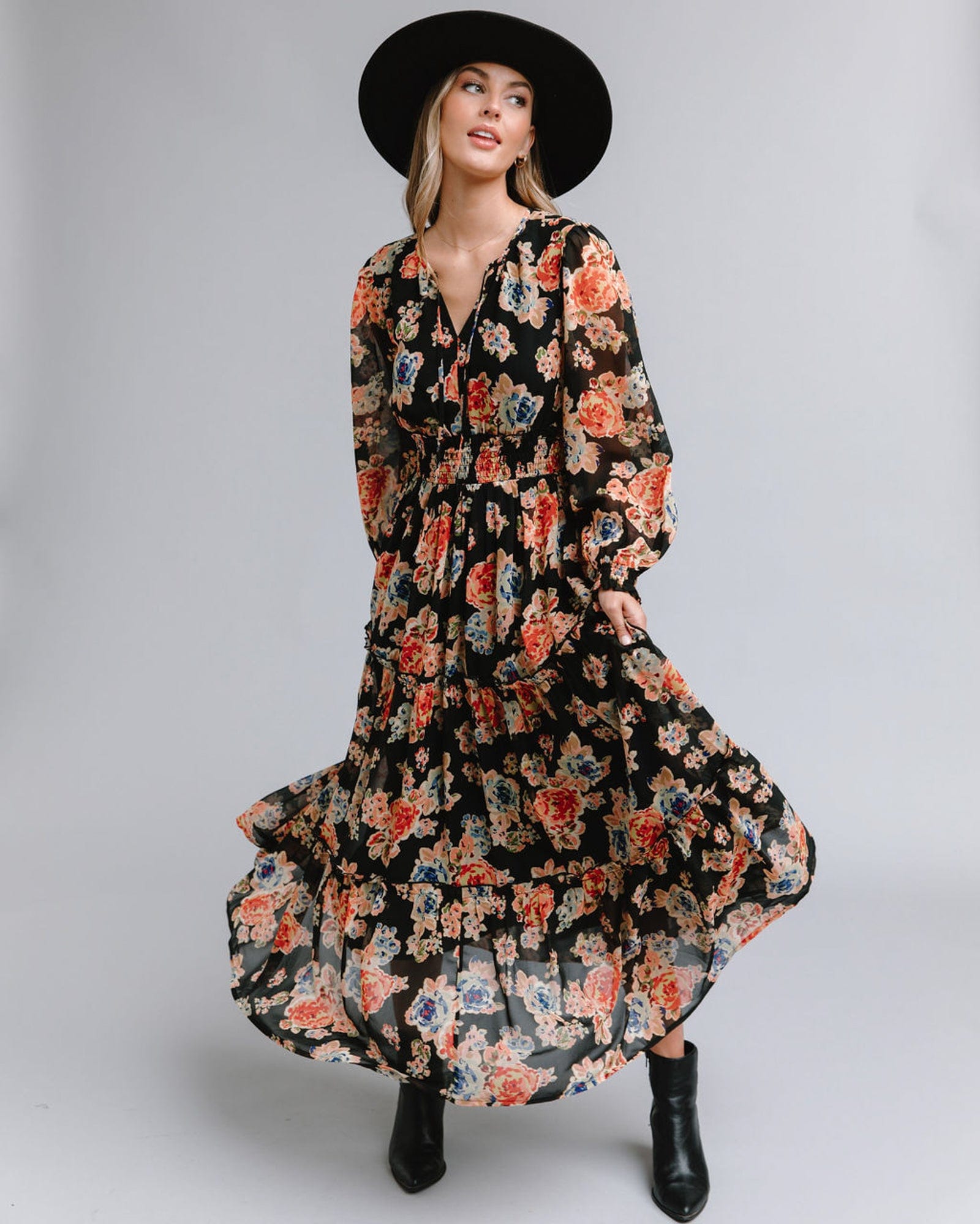 Woman in a long sleeve, maxi length, black with multi-color floral accents