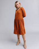 Woman in a long sleeve, button-down, orange dress