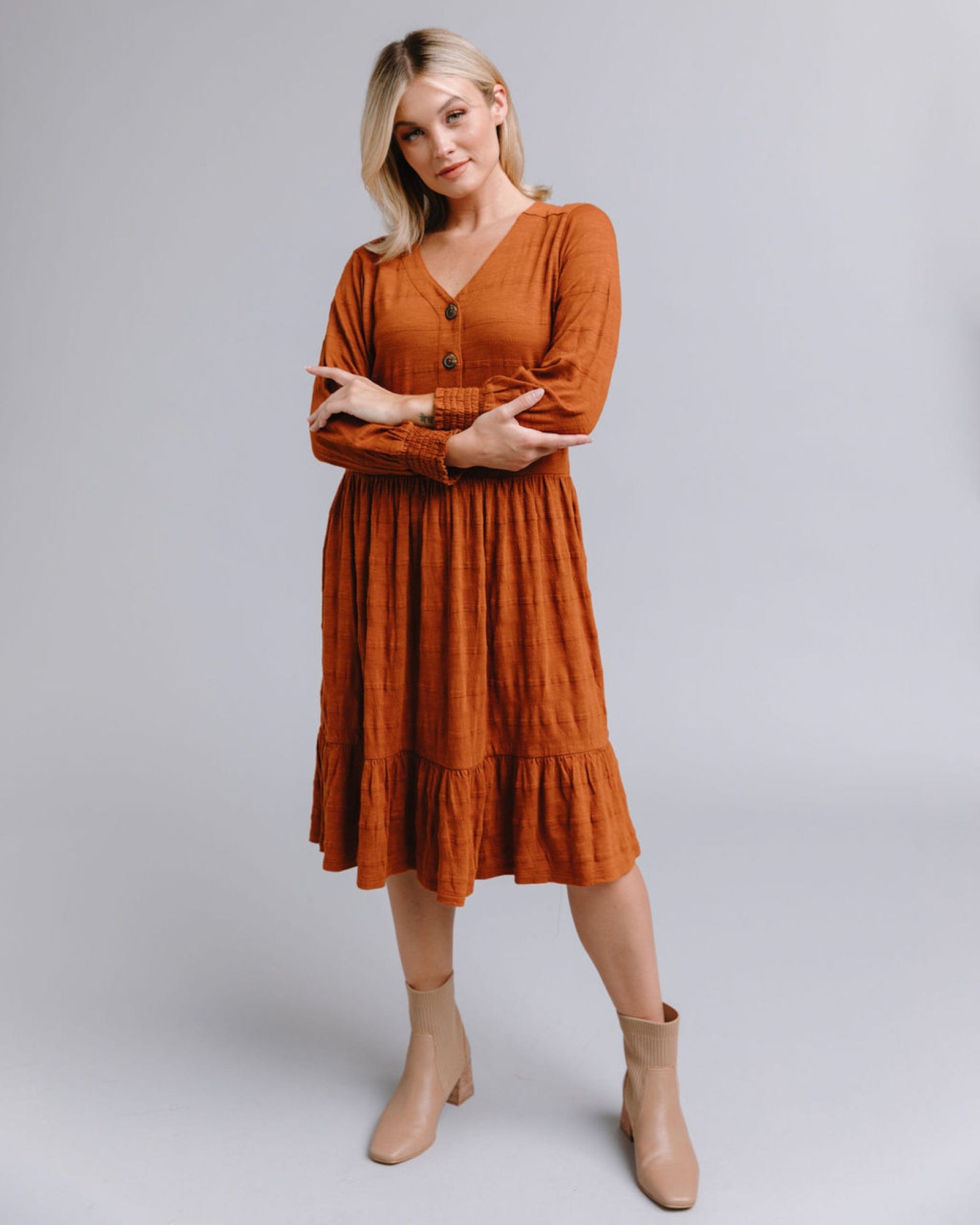 Woman in a long sleeve, button-down, orange dress