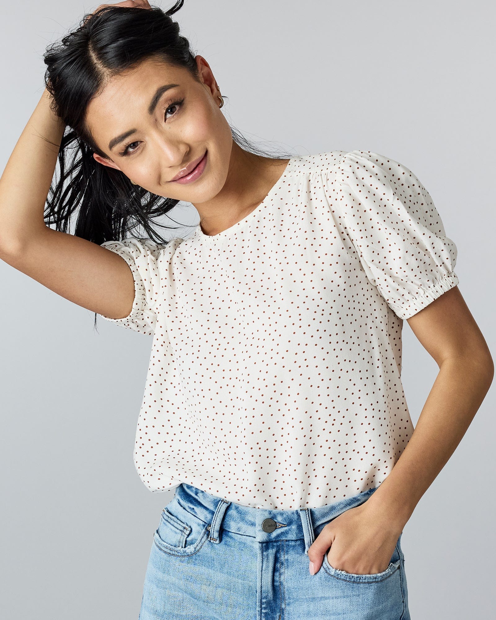 Woman in a short sleeve polka dotted blouse. 