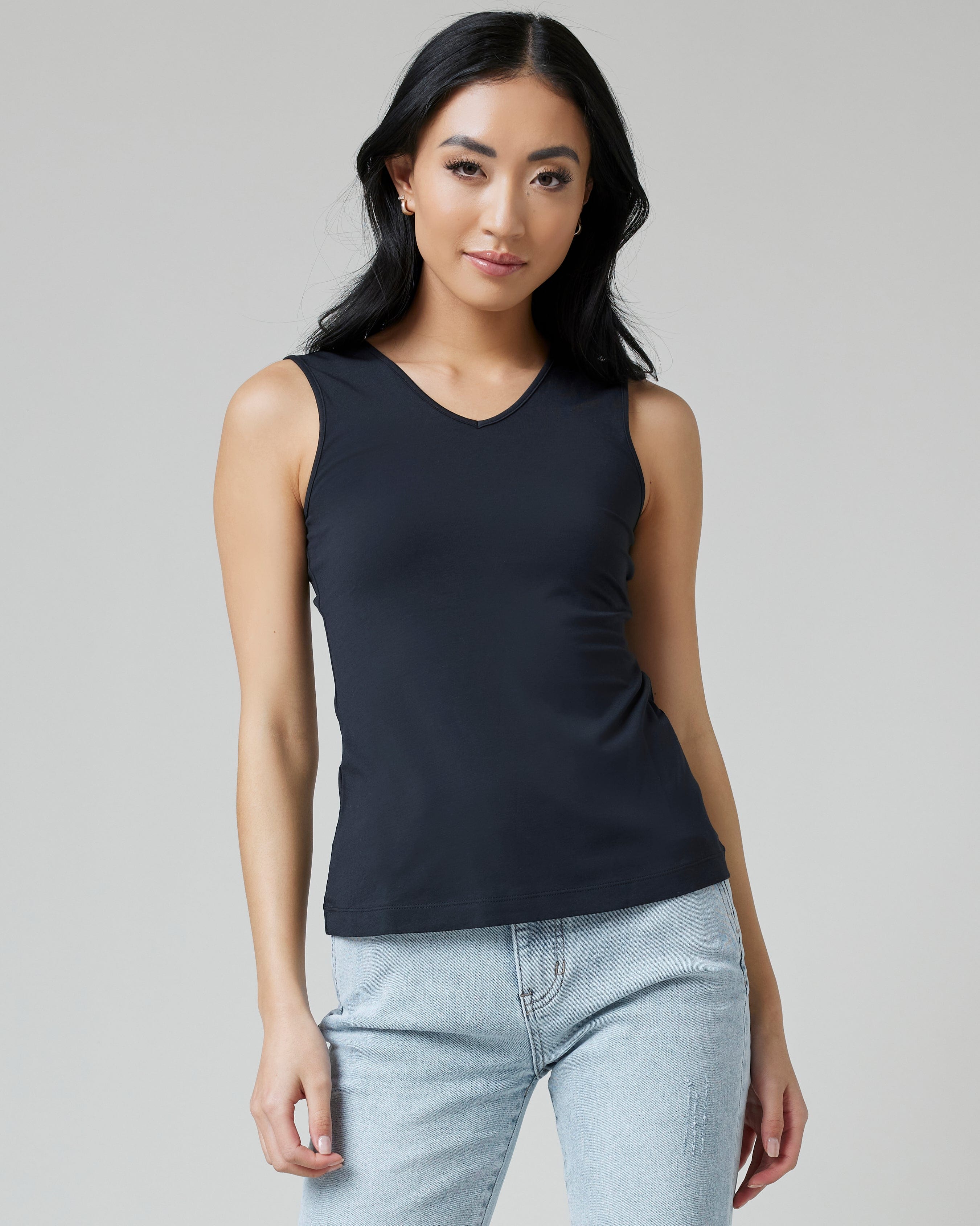 Woman in sleeveless, fitted, basic tank top