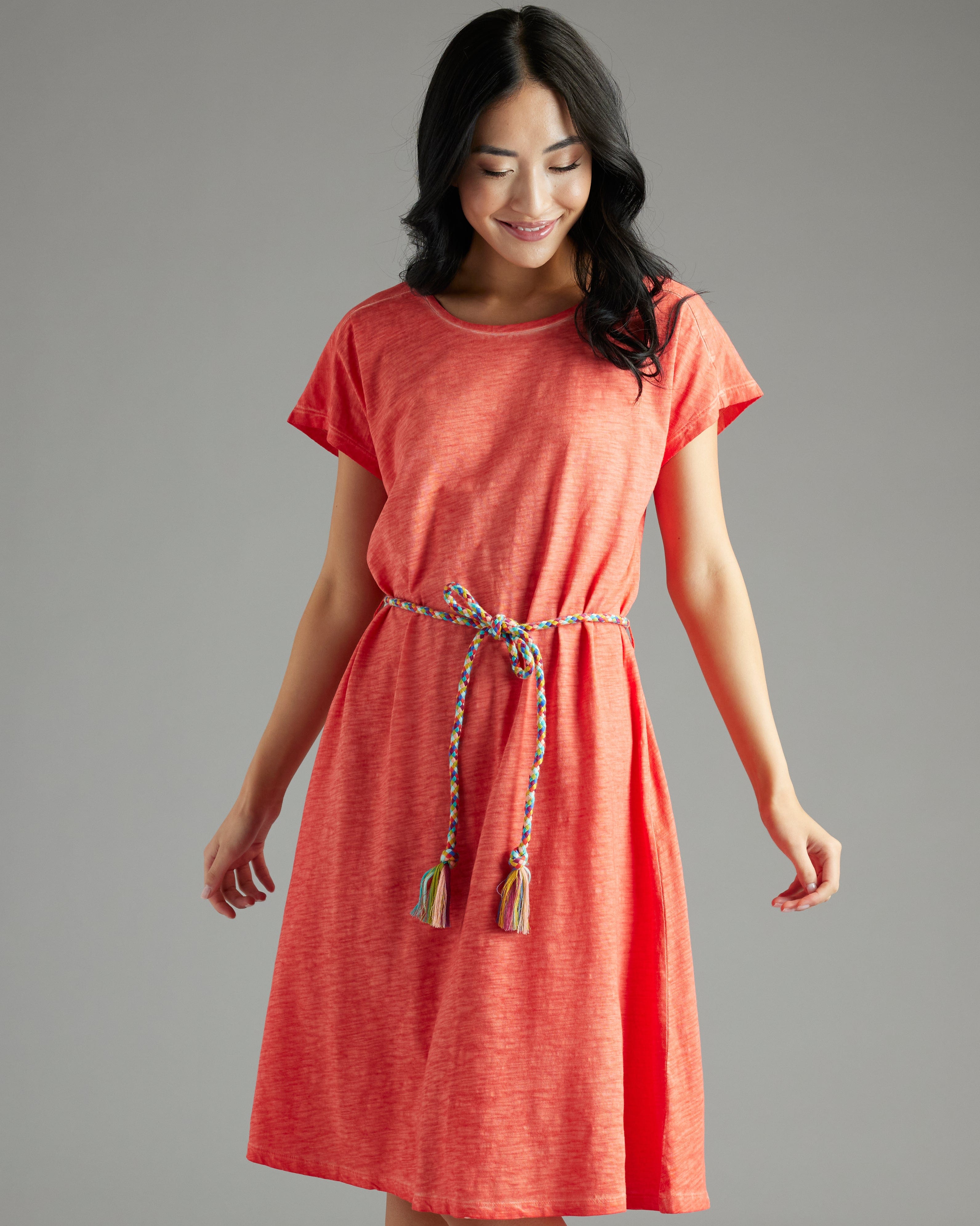 Woman in a short sleeve, knee-length orange dress with tie around waist