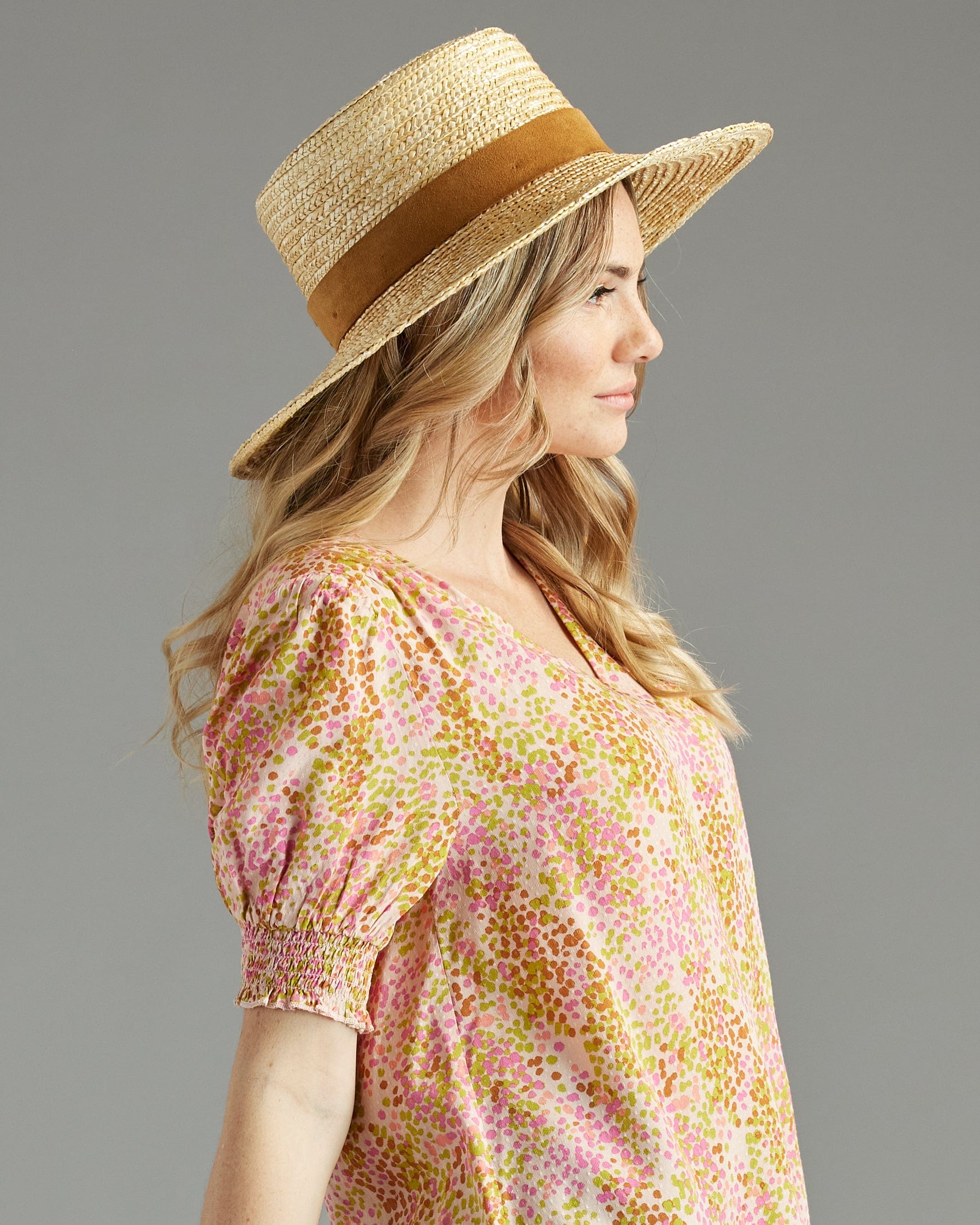 Woman in a yellow and pink print blouse with short sleeves and a v-neck