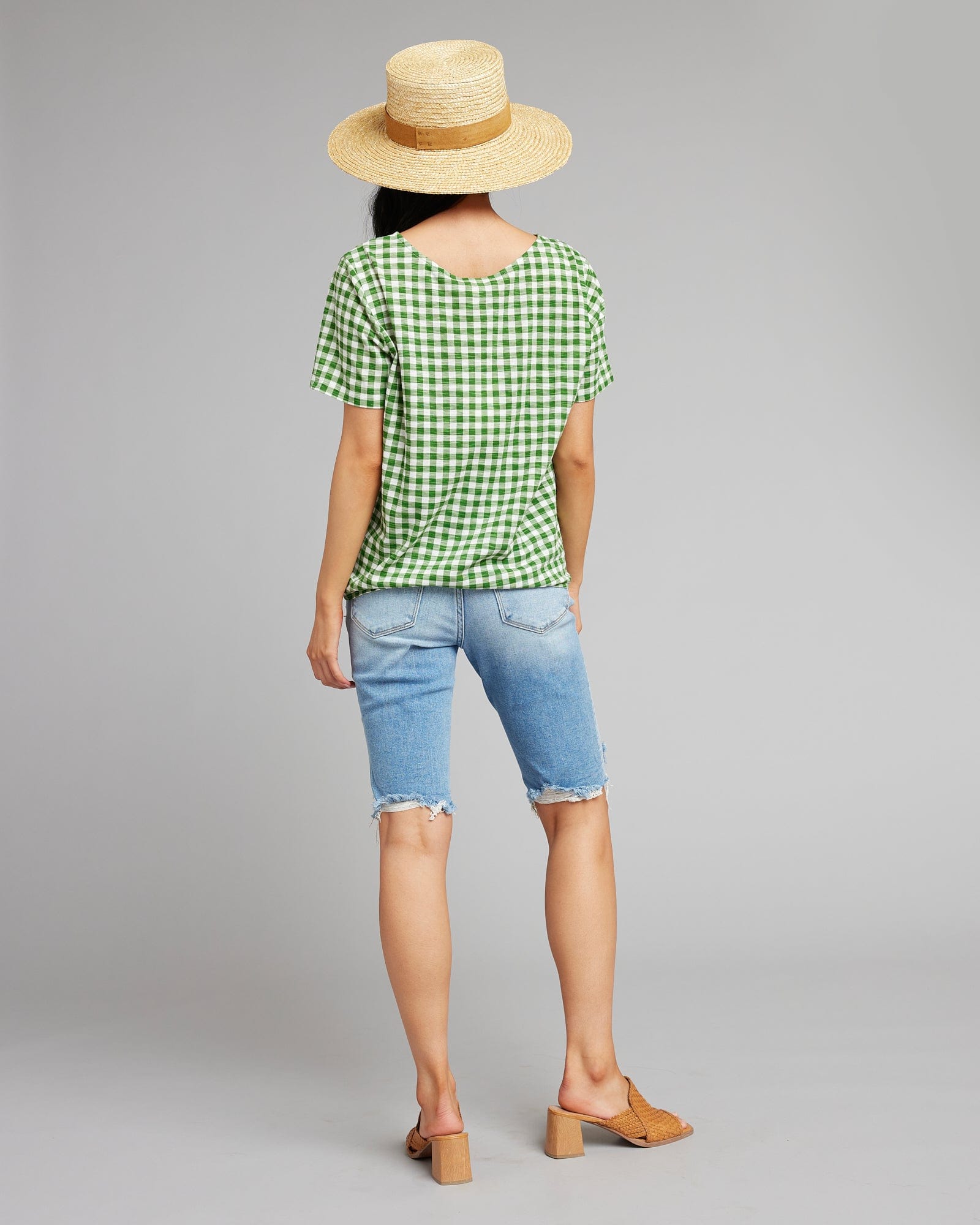 Woman in a green and white gingham top with short sleeves 