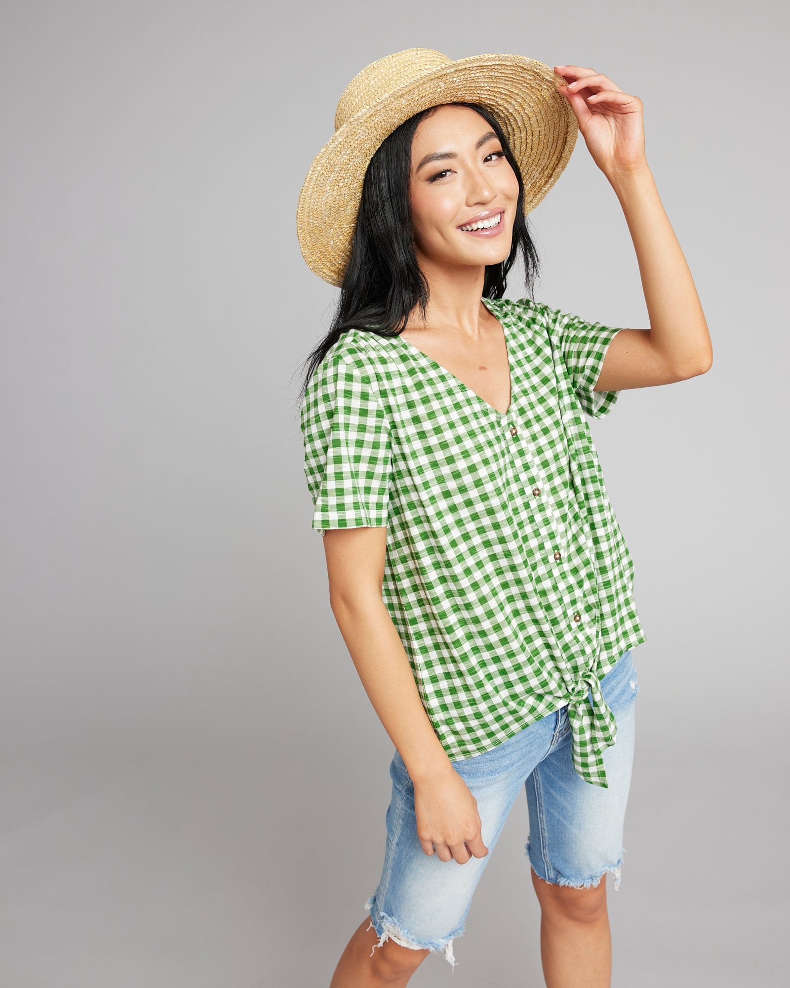 Woman in a green and white gingham top with short sleeves 