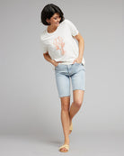 Woman in a white short sleeved graphic tee with a lobster on the front