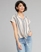 Woman in a gray, white and pink vertical striped button-down with short sleeves
