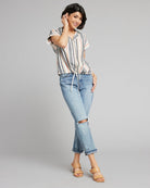 Woman in a gray, white and pink vertical striped button-down with short sleeves