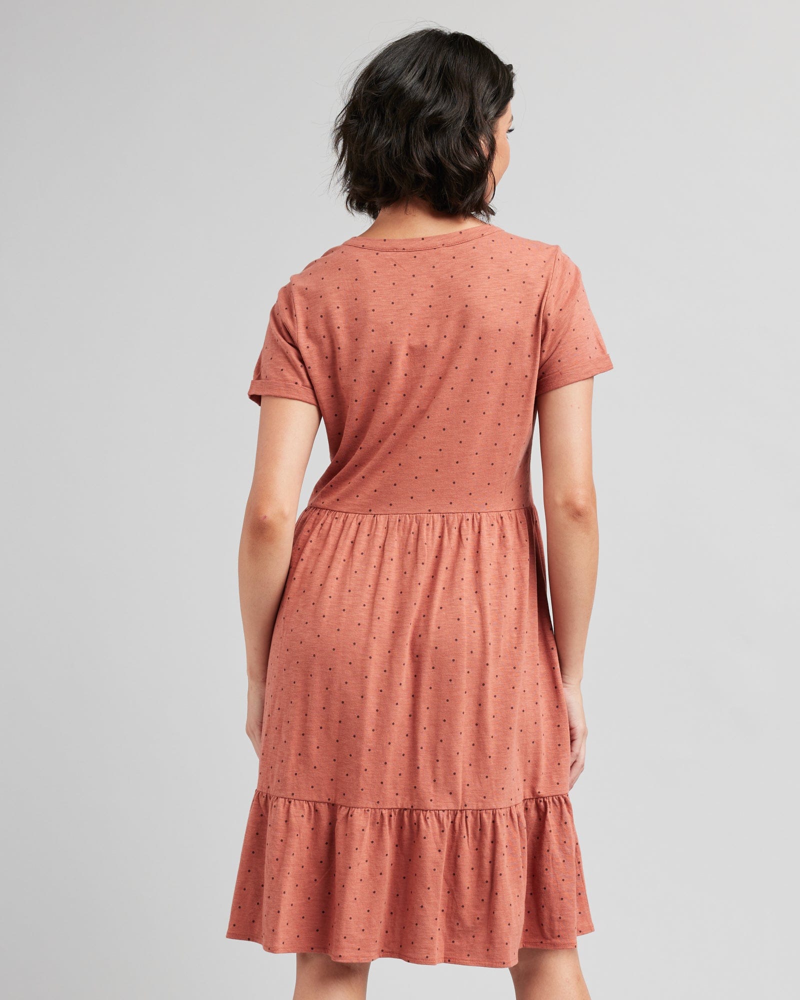 Woman in a short sleeve, henley top, dotted swiss, orange dress