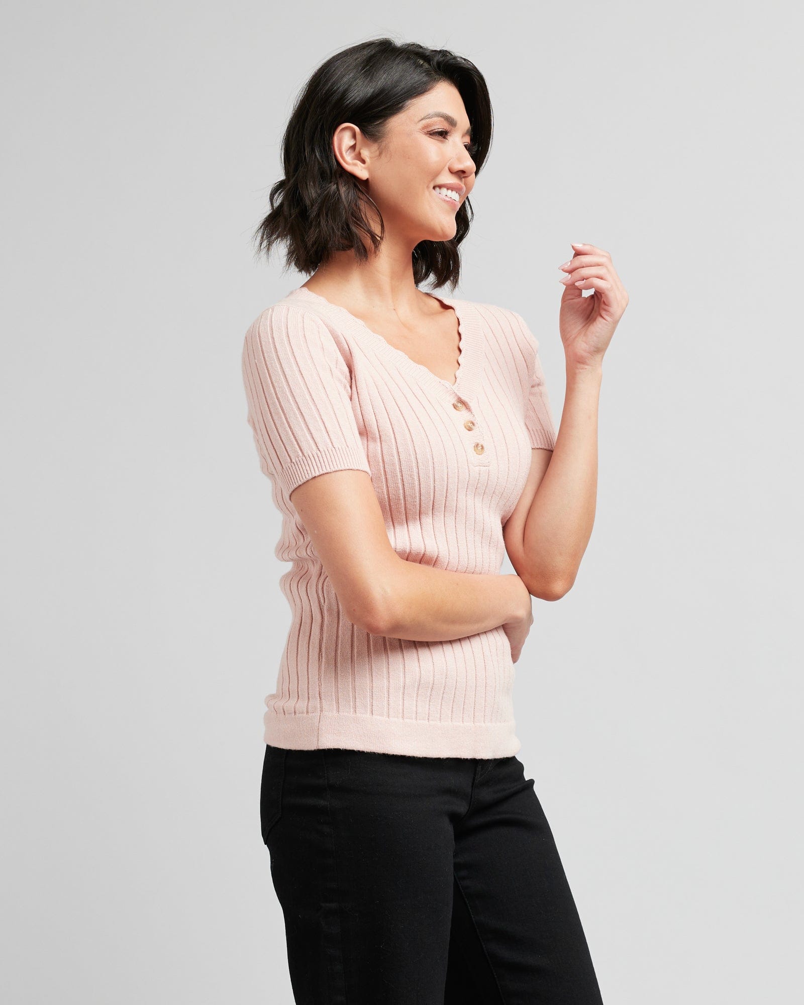 Woman in a pink ribbed short sleeve sweater