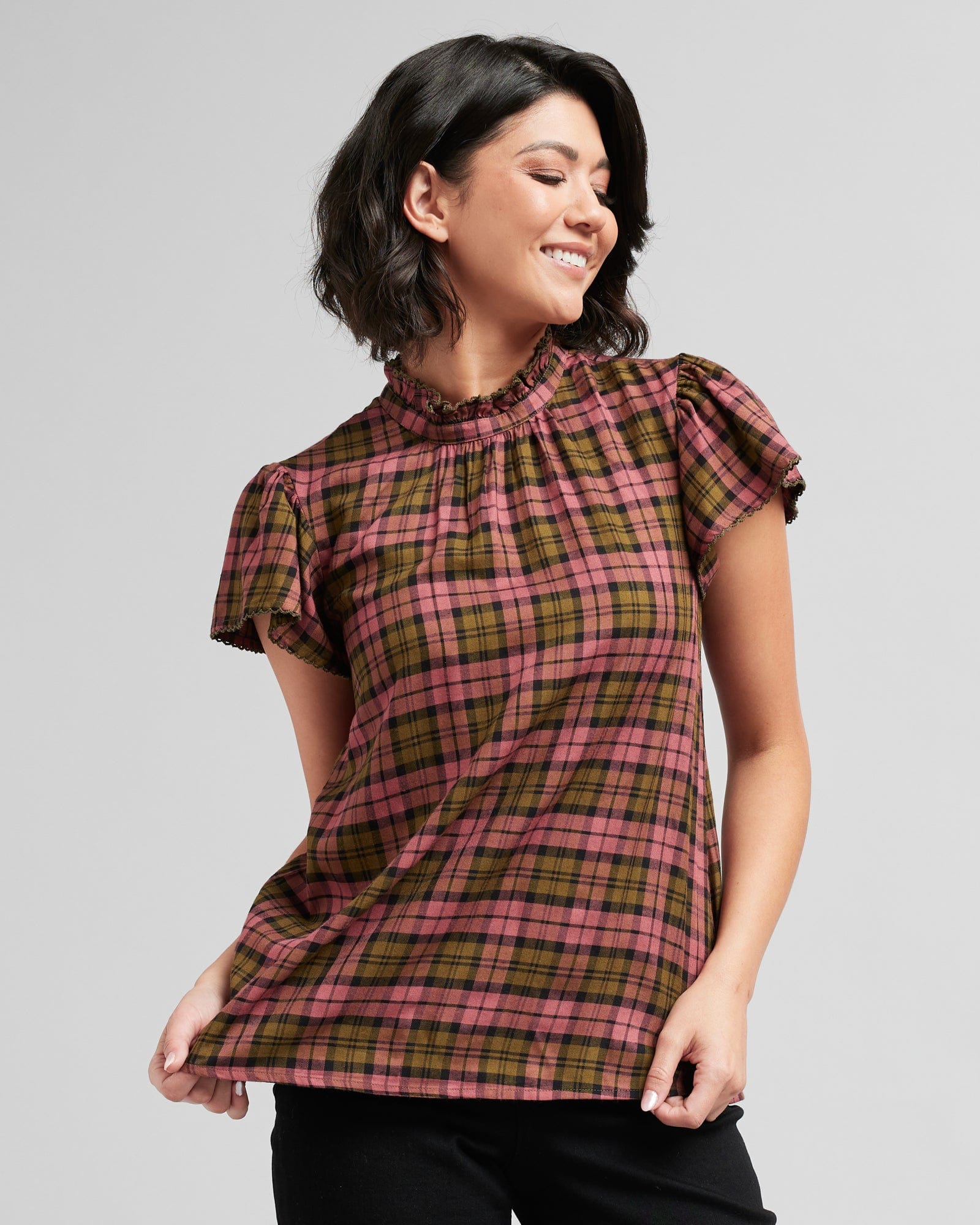 Woman in a short sleeve, mock neck, plaid blouse