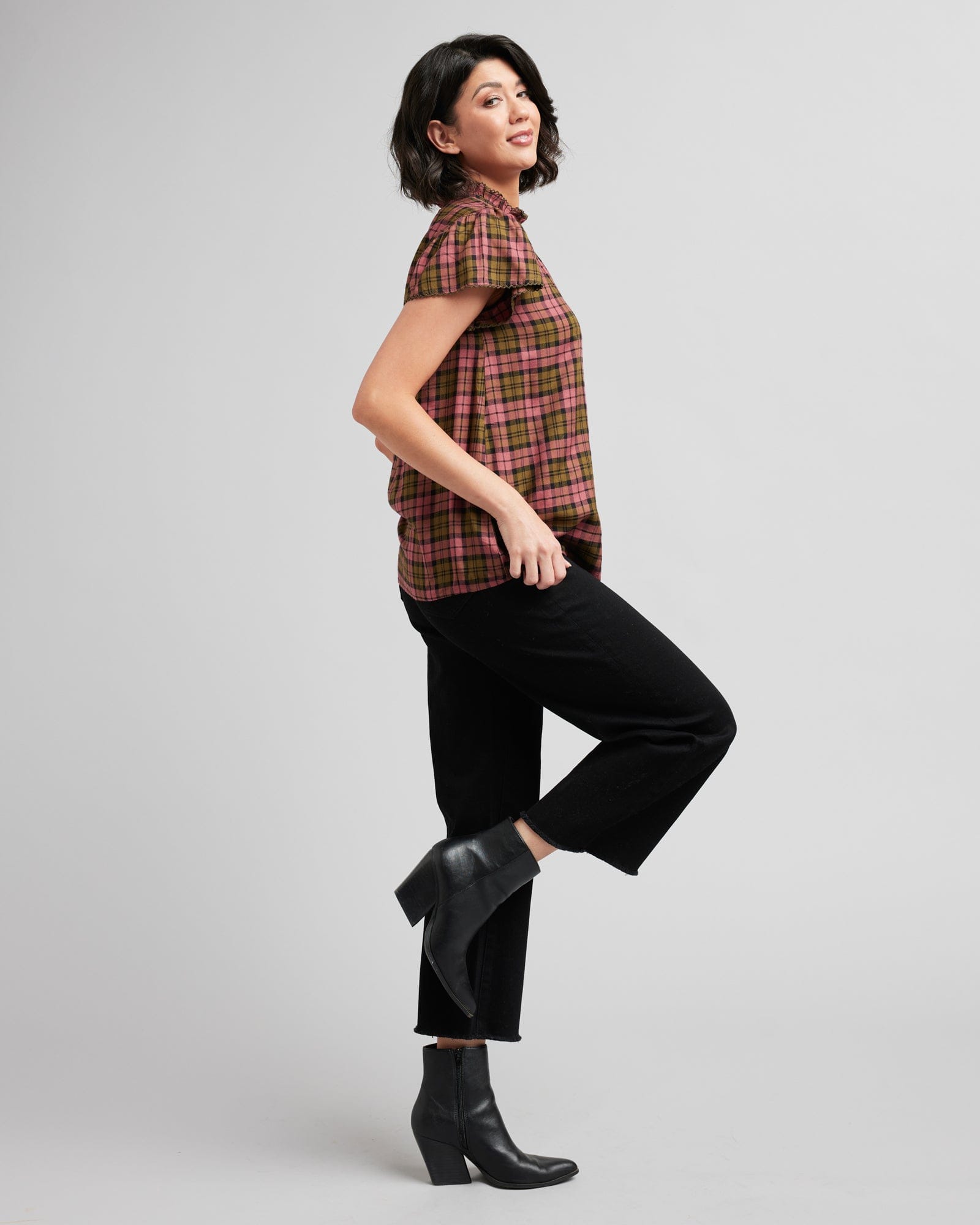 Woman in a short sleeve, mock neck, plaid blouse