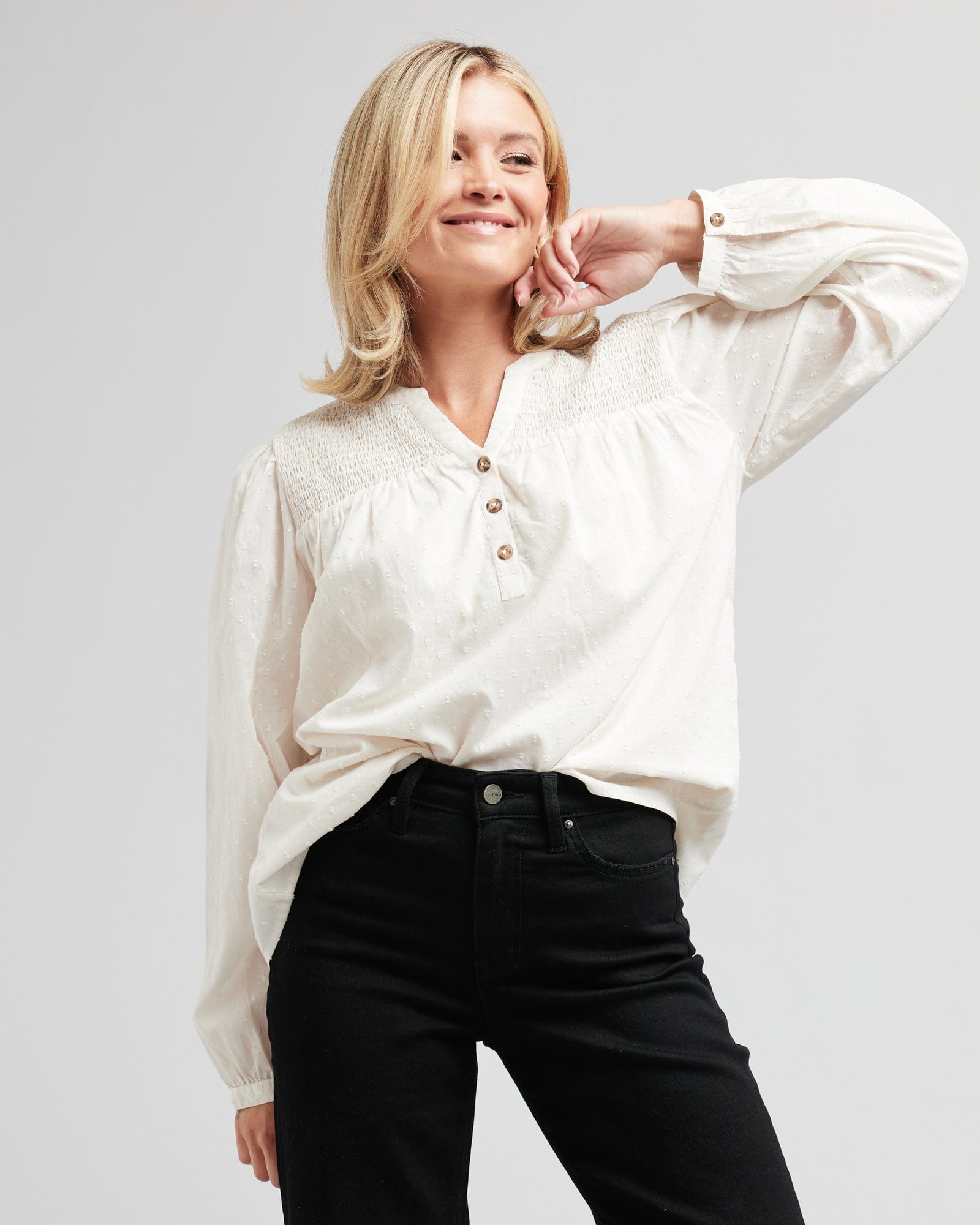 Woman in a long sleeve, v-neck, white blouse