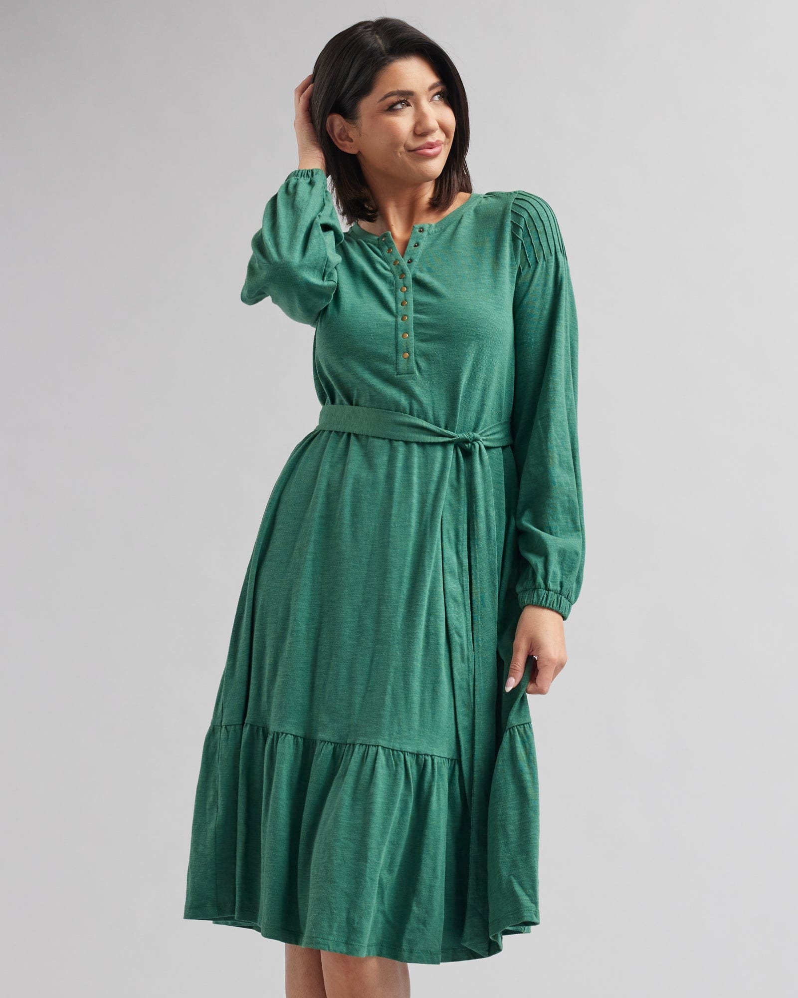 Woman in a long sleeve, midi-length, green dress