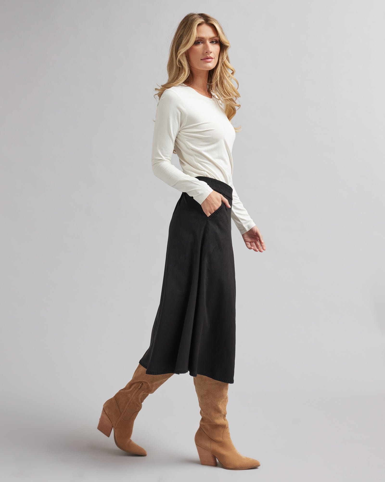 Woman in a black, midi-length, suede skirt