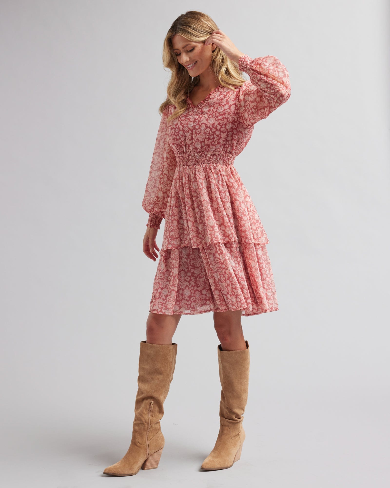 Woman in a long sleeve, knee-length, pink floral printed dress