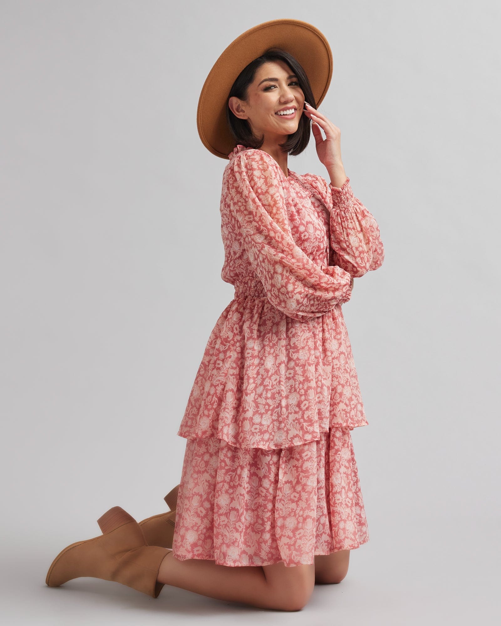 Woman in a long sleeve, knee-length, pink floral printed dress
