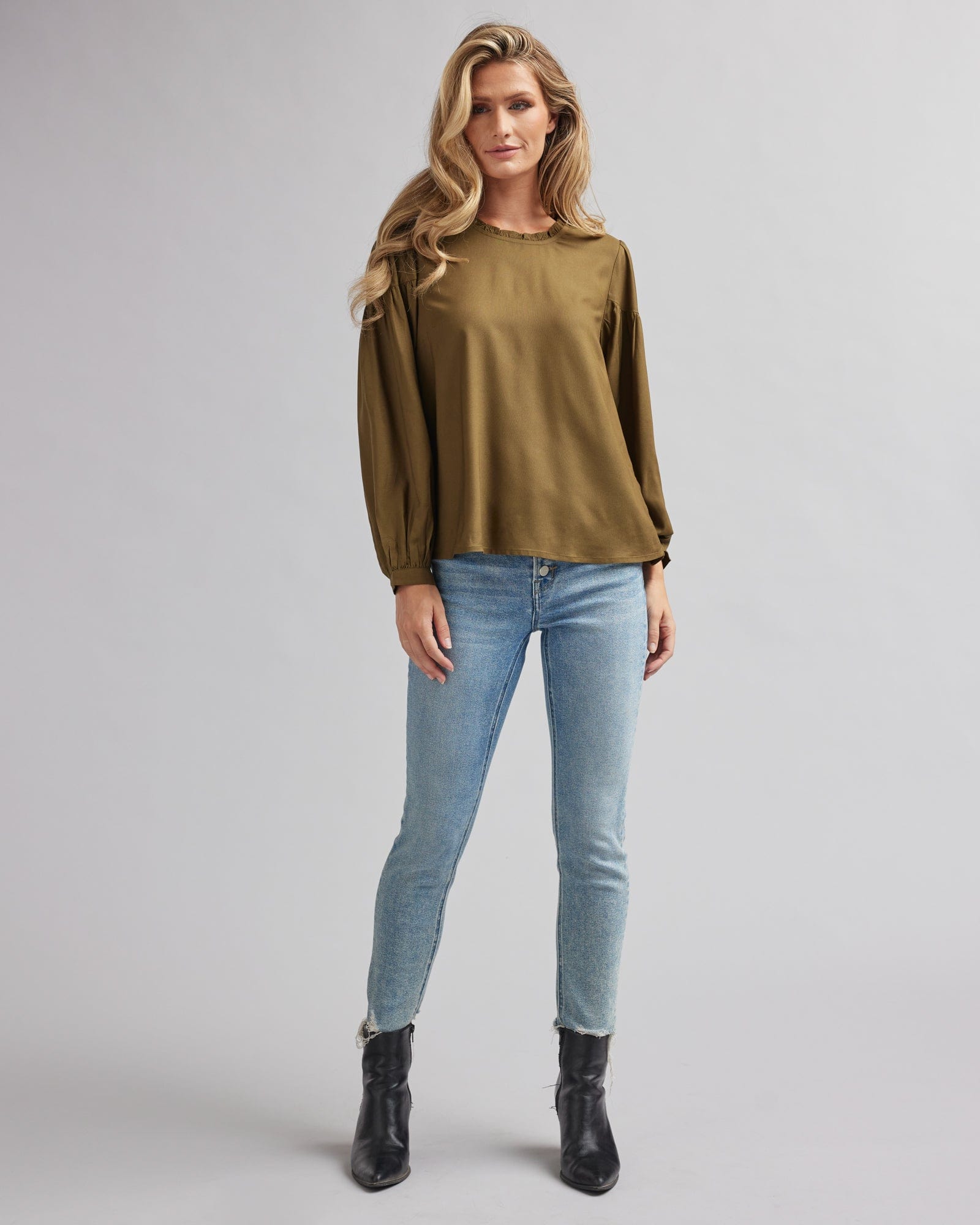Woman in an olive green, ong sleeve blouse