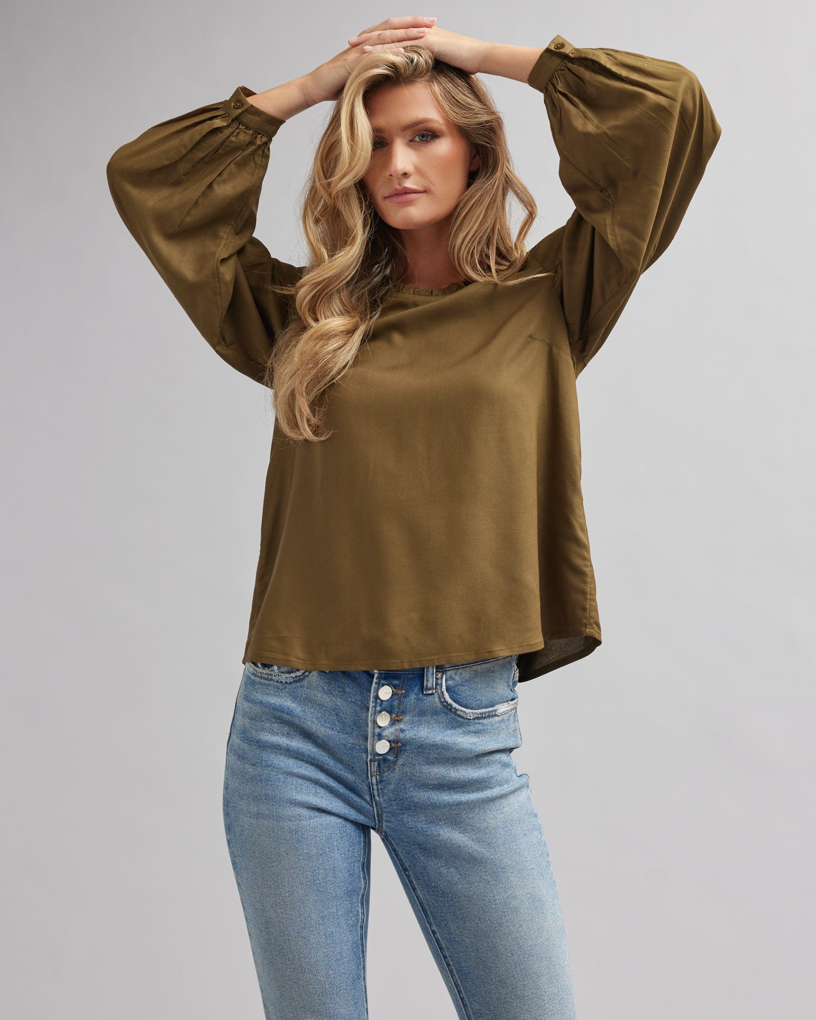 Woman in an olive green, ong sleeve blouse