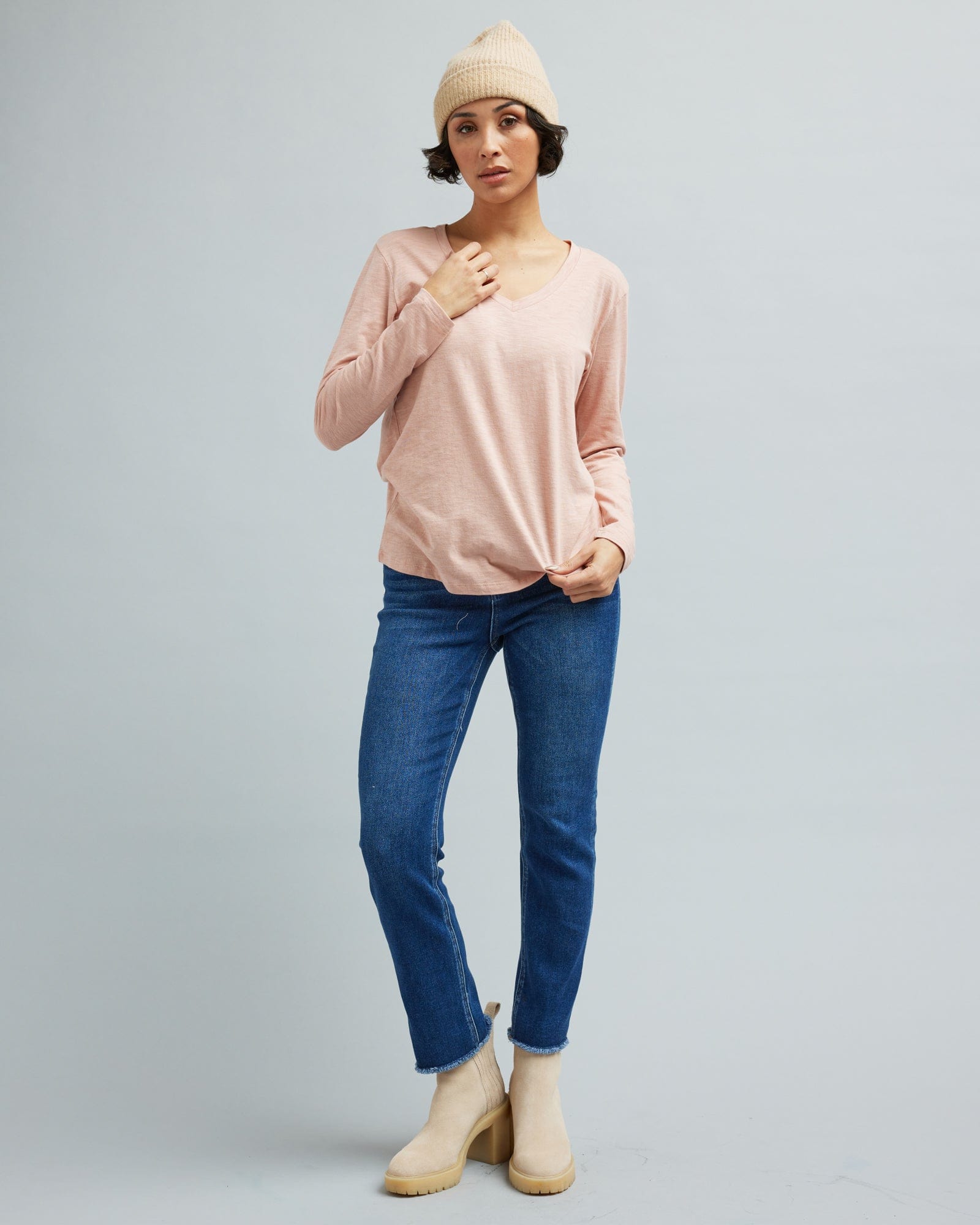 Woman in a long sleeve, pink v-neck t-shirt