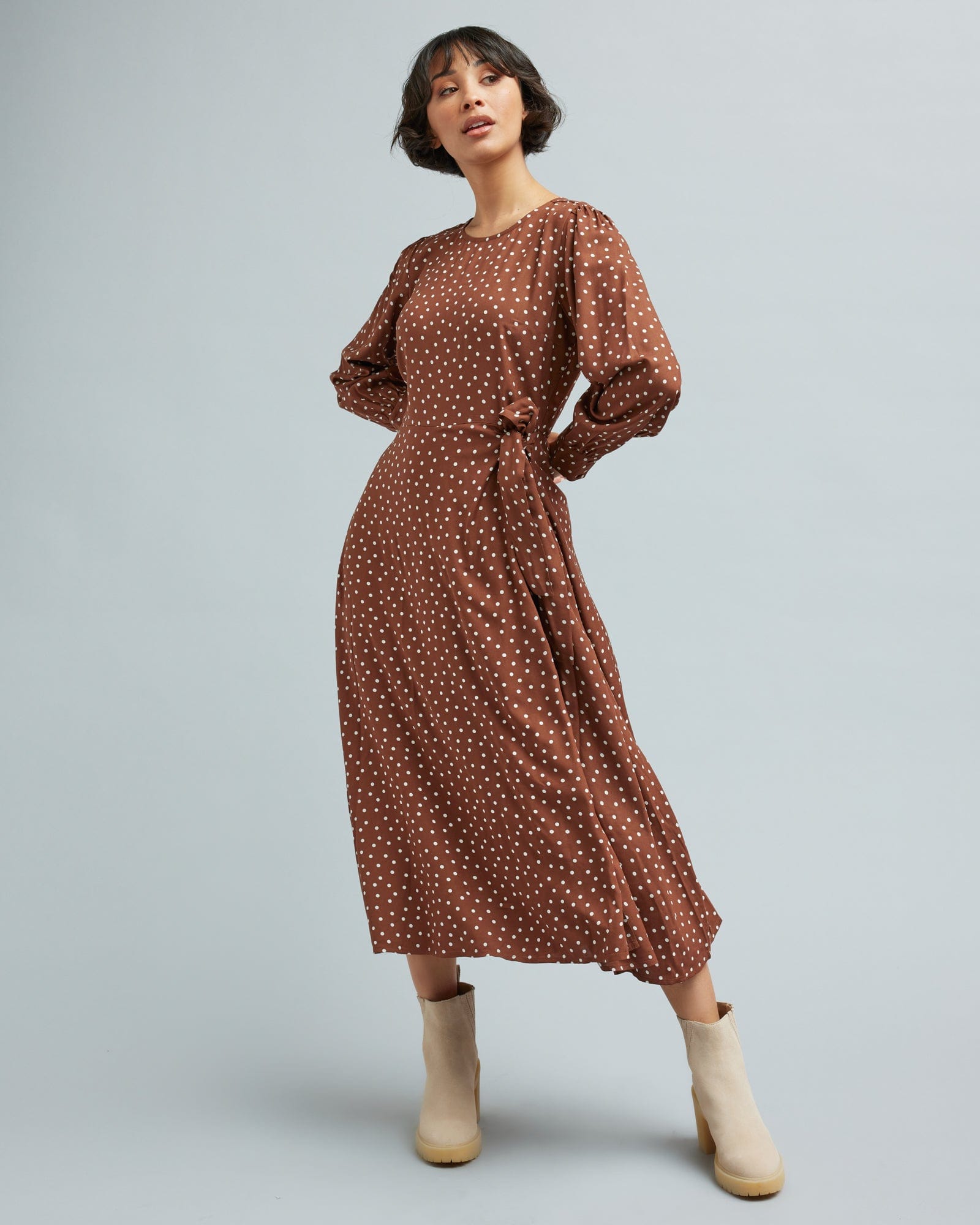 Woman in a brown with white polka dot, long sleeve dress