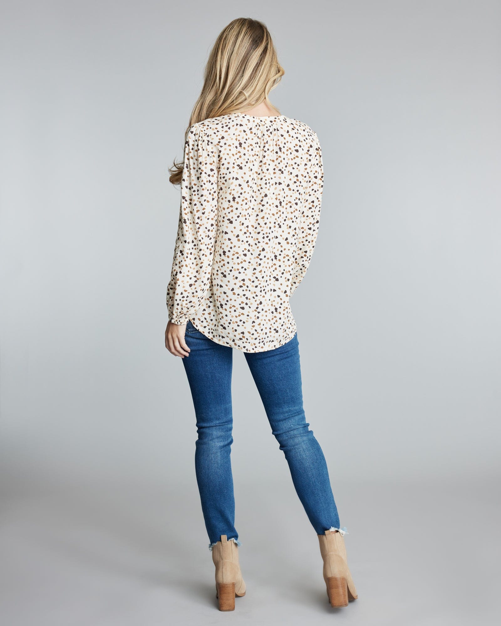 Woman in a long sleeve, polka dotted blouse