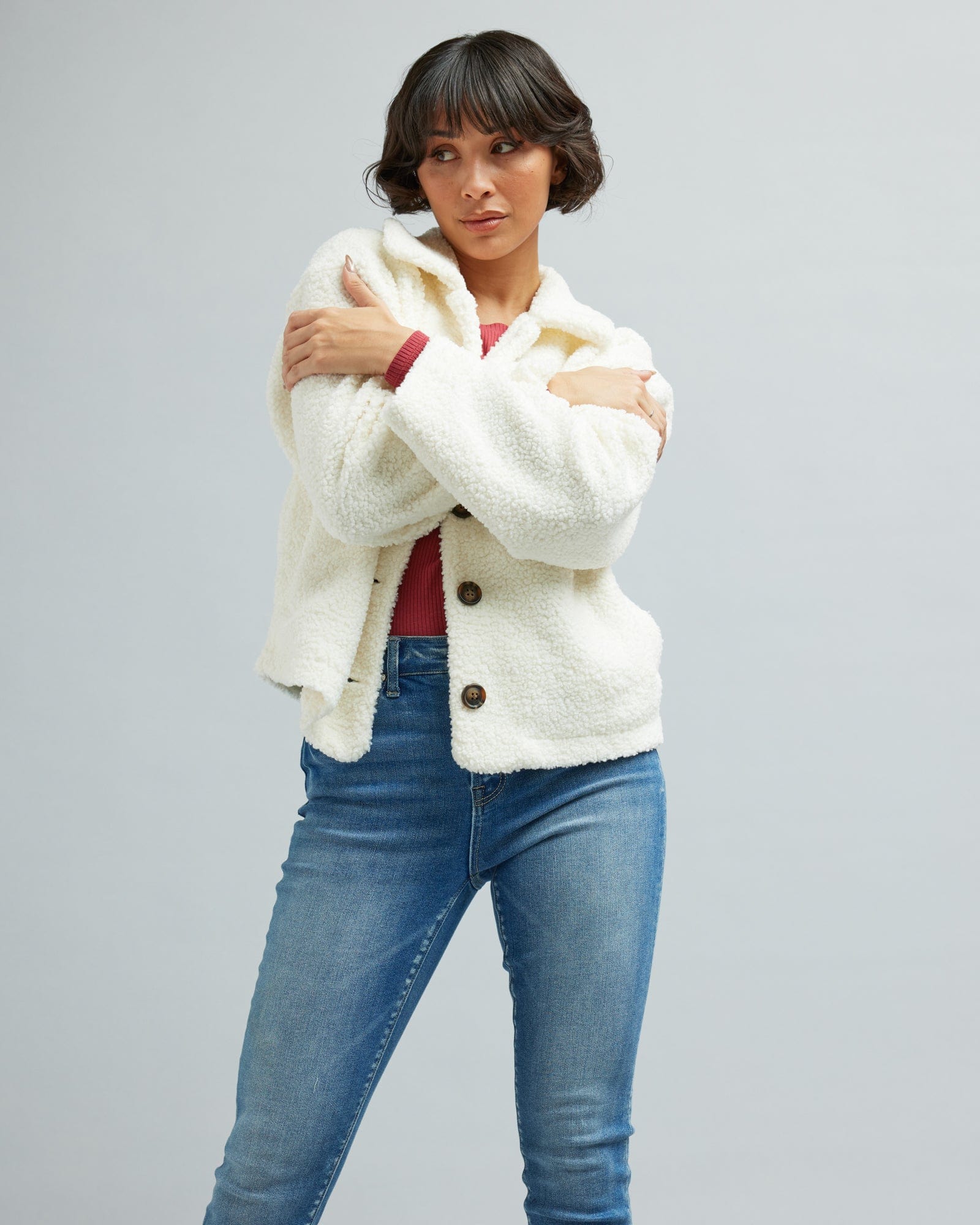 Woman in a long sleeve, white, sherpa jacket