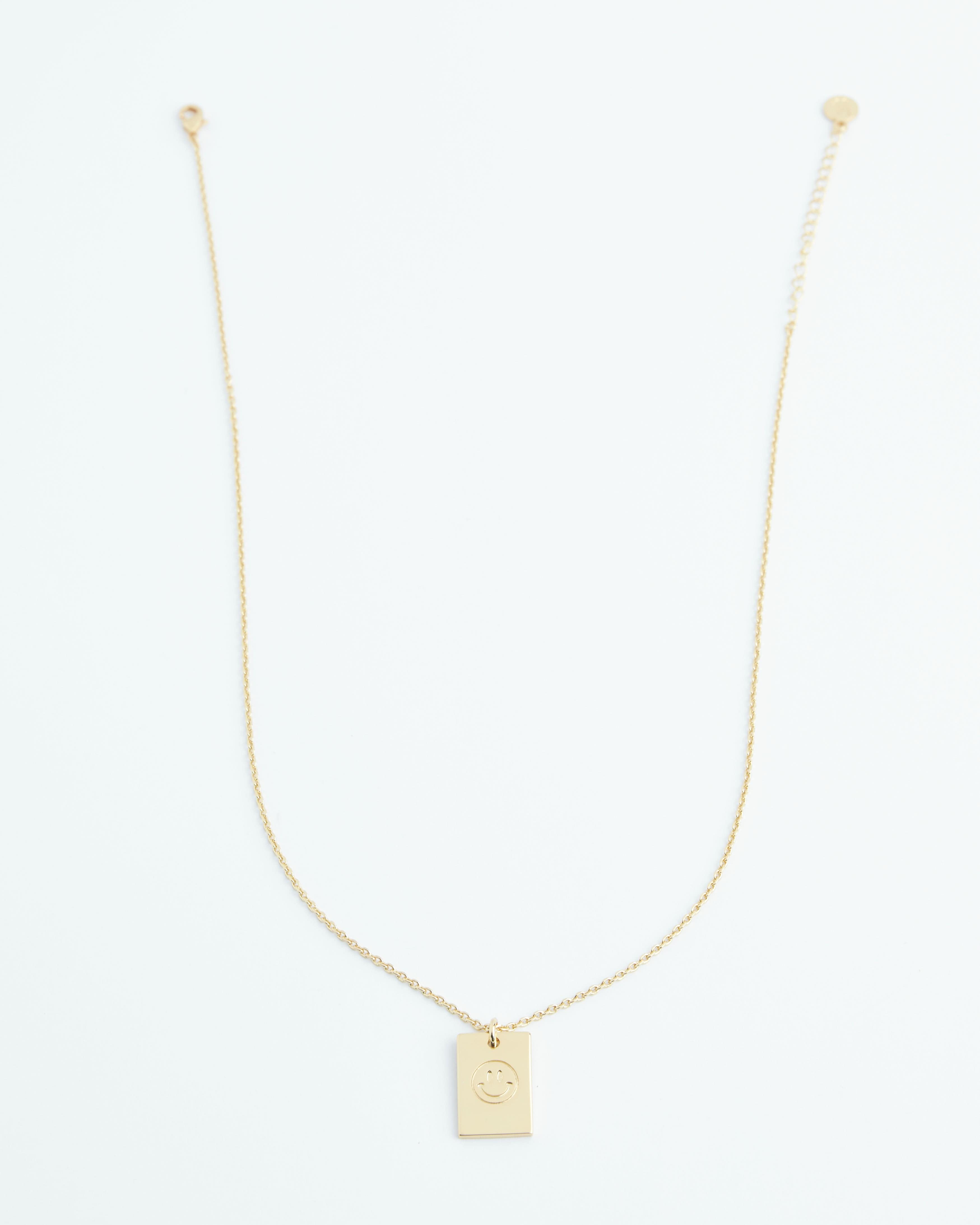 Gold necklace with smiley face on pendant