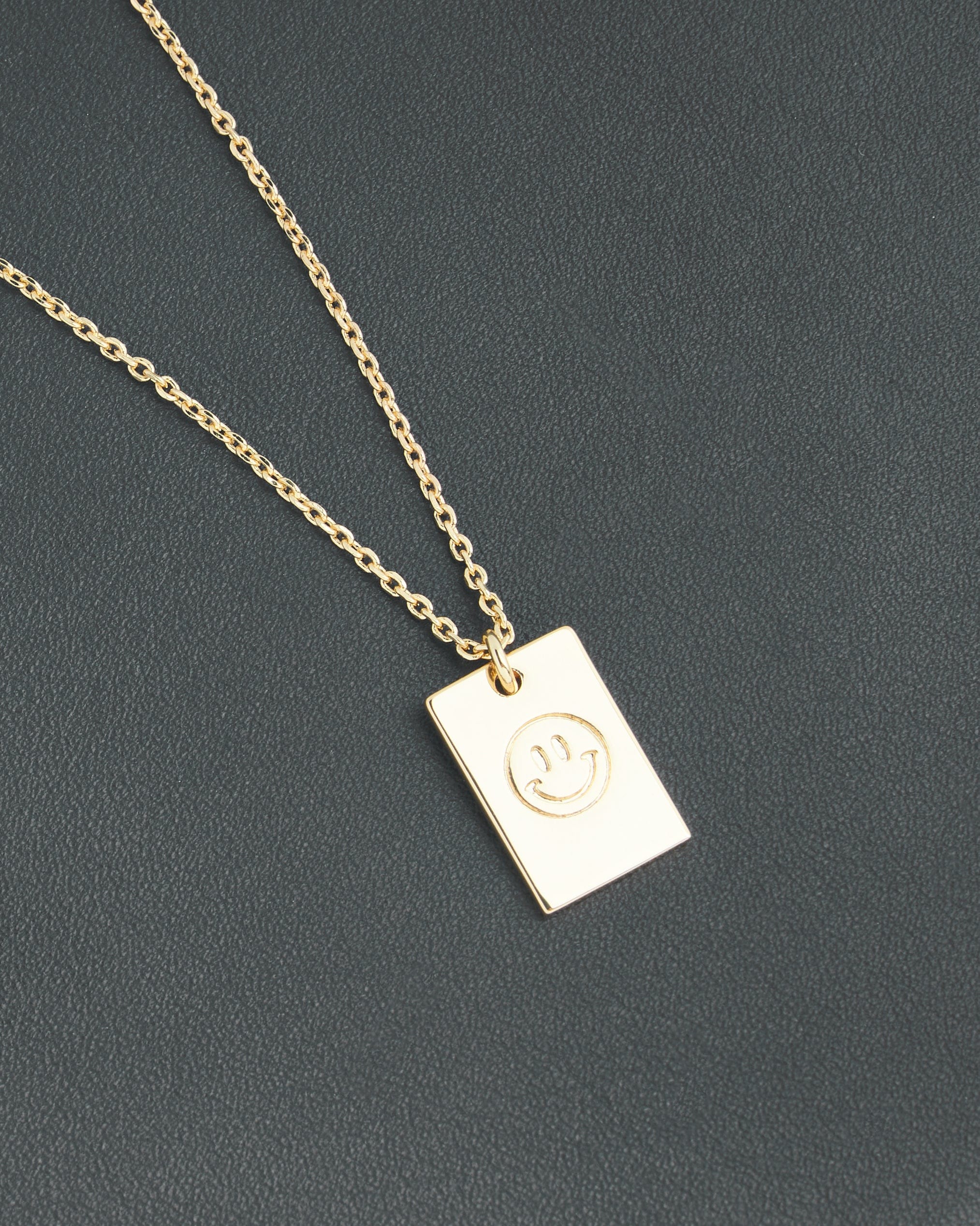 Gold necklace with smiley face on pendant