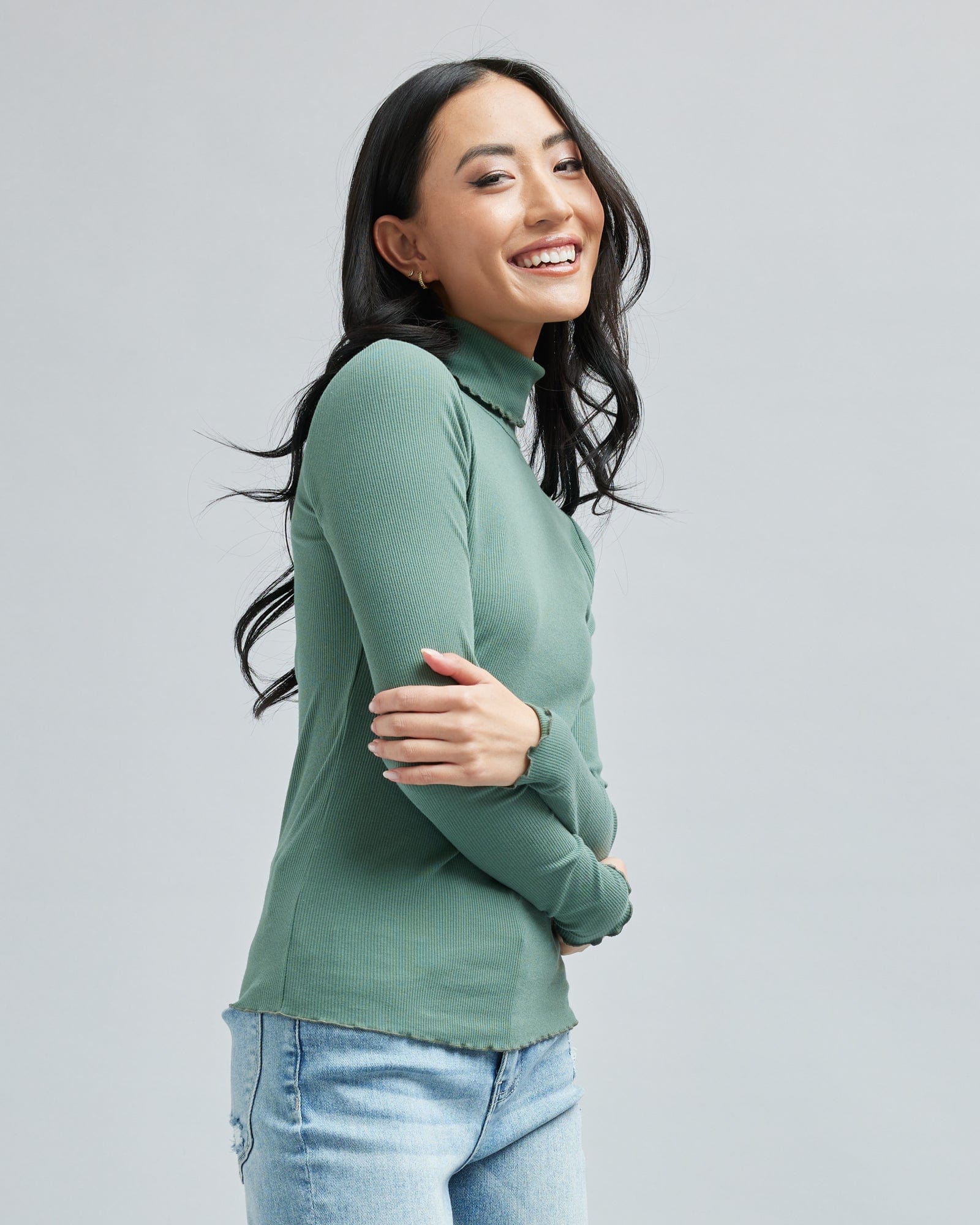 Woman in a long sleeve, green, turtleneck t-shirt