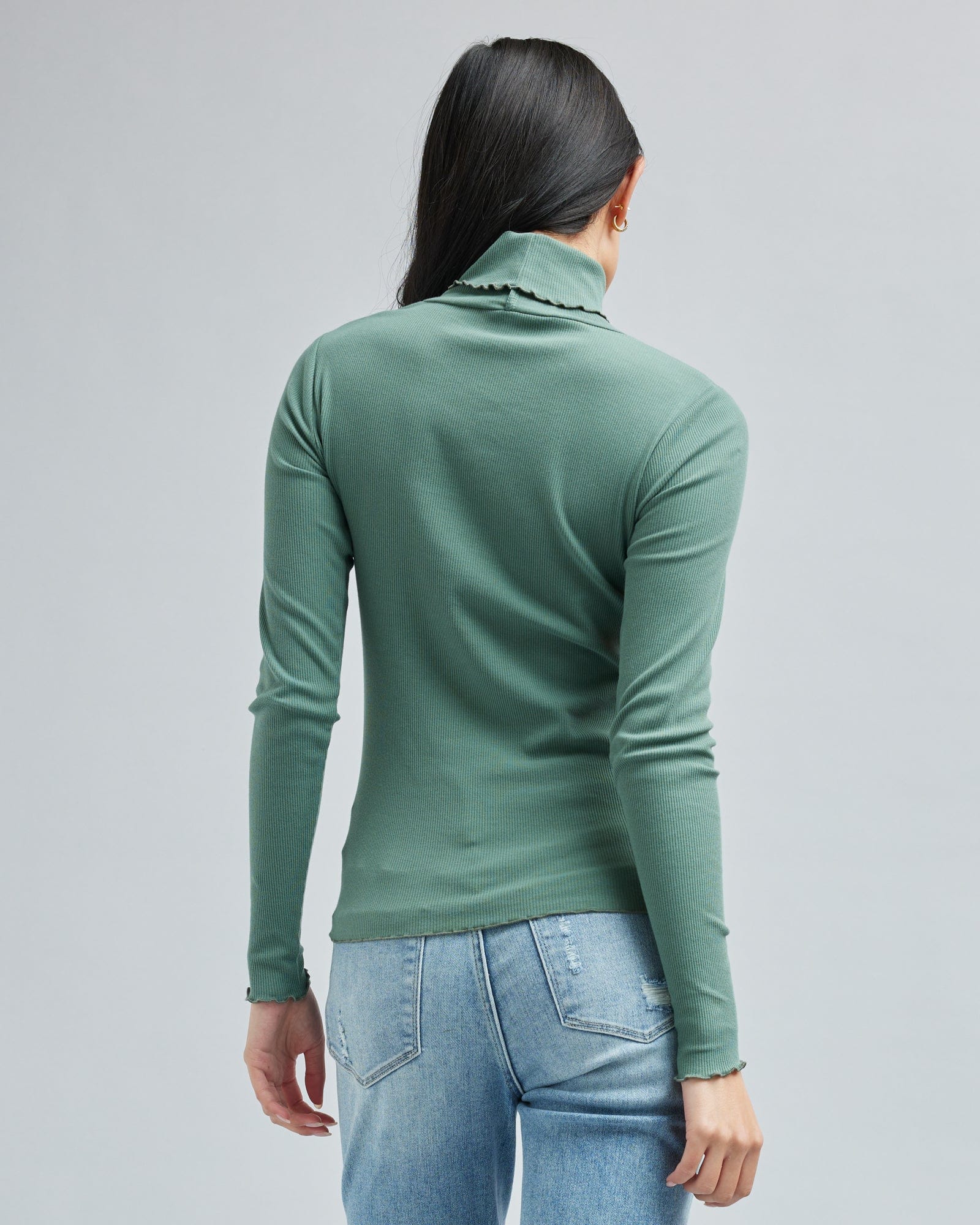Woman in a long sleeve, green, turtleneck t-shirt