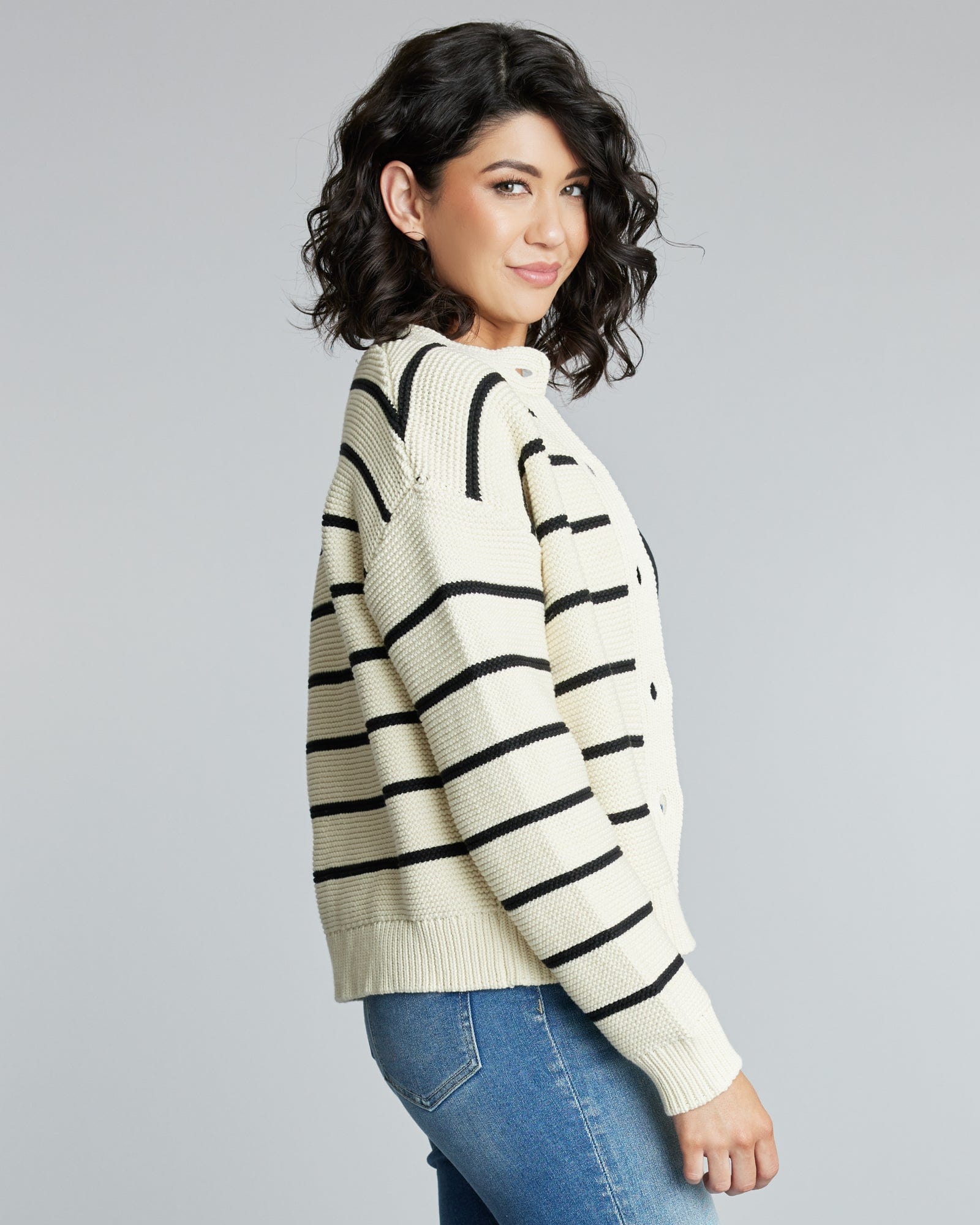 Woman in a long sleeve, black and white striped cardigan